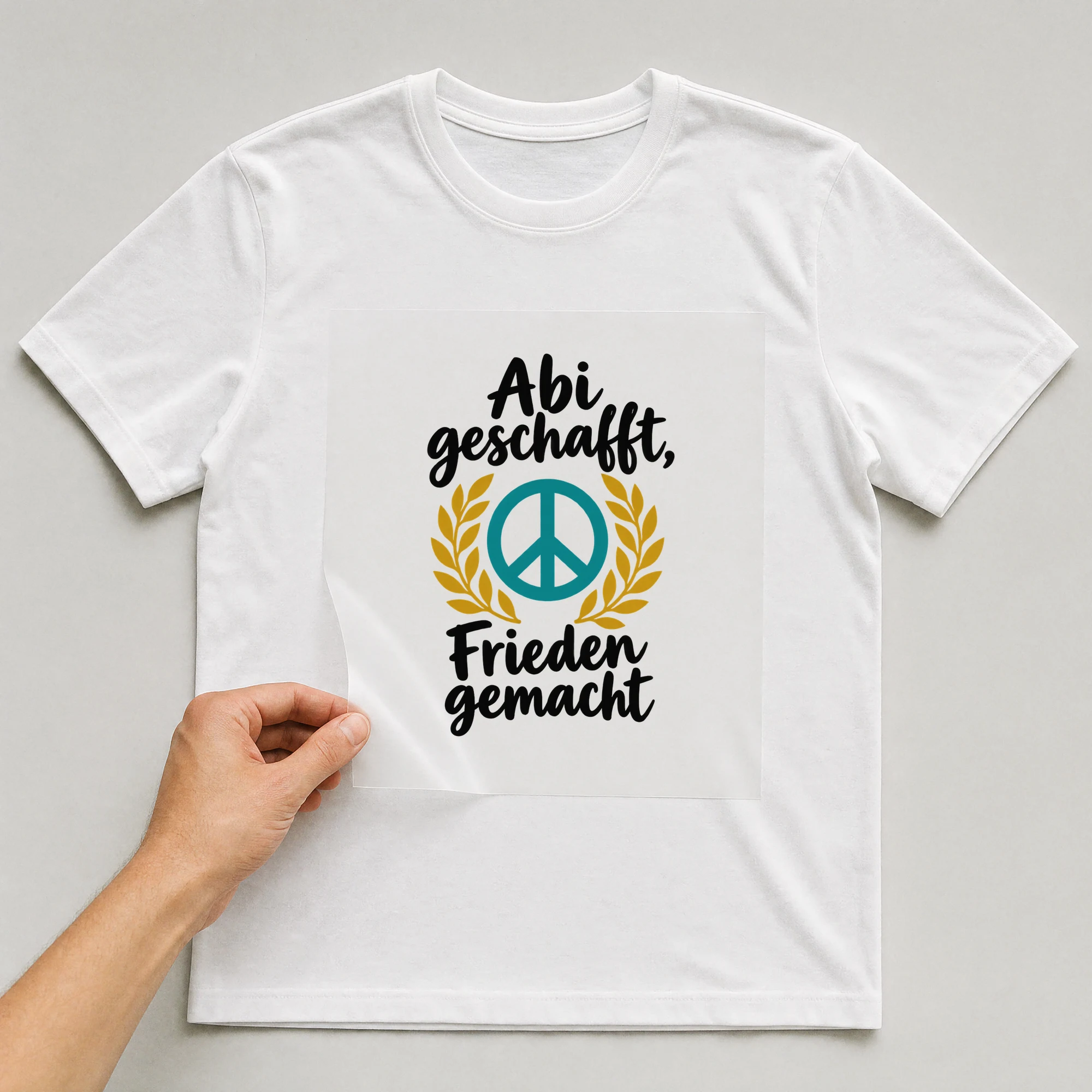 Bügelbild „Abi geschafft, Frieden gemacht“ auf weißem T-Shirt, Folie wird aufgelegt