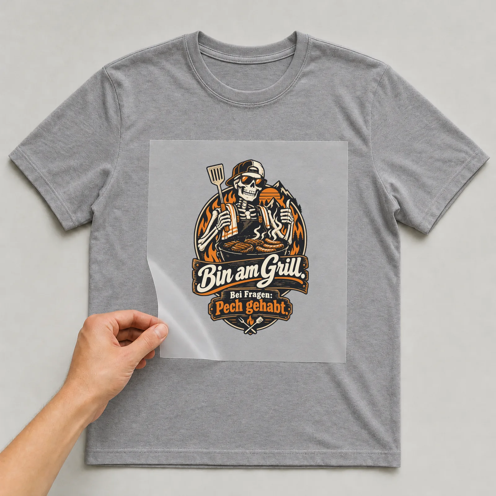 Bügelbild Bin am Grill. Bei Fragen: Pech gehabt. auf grauem T-Shirt, Folie wird aufgelegt