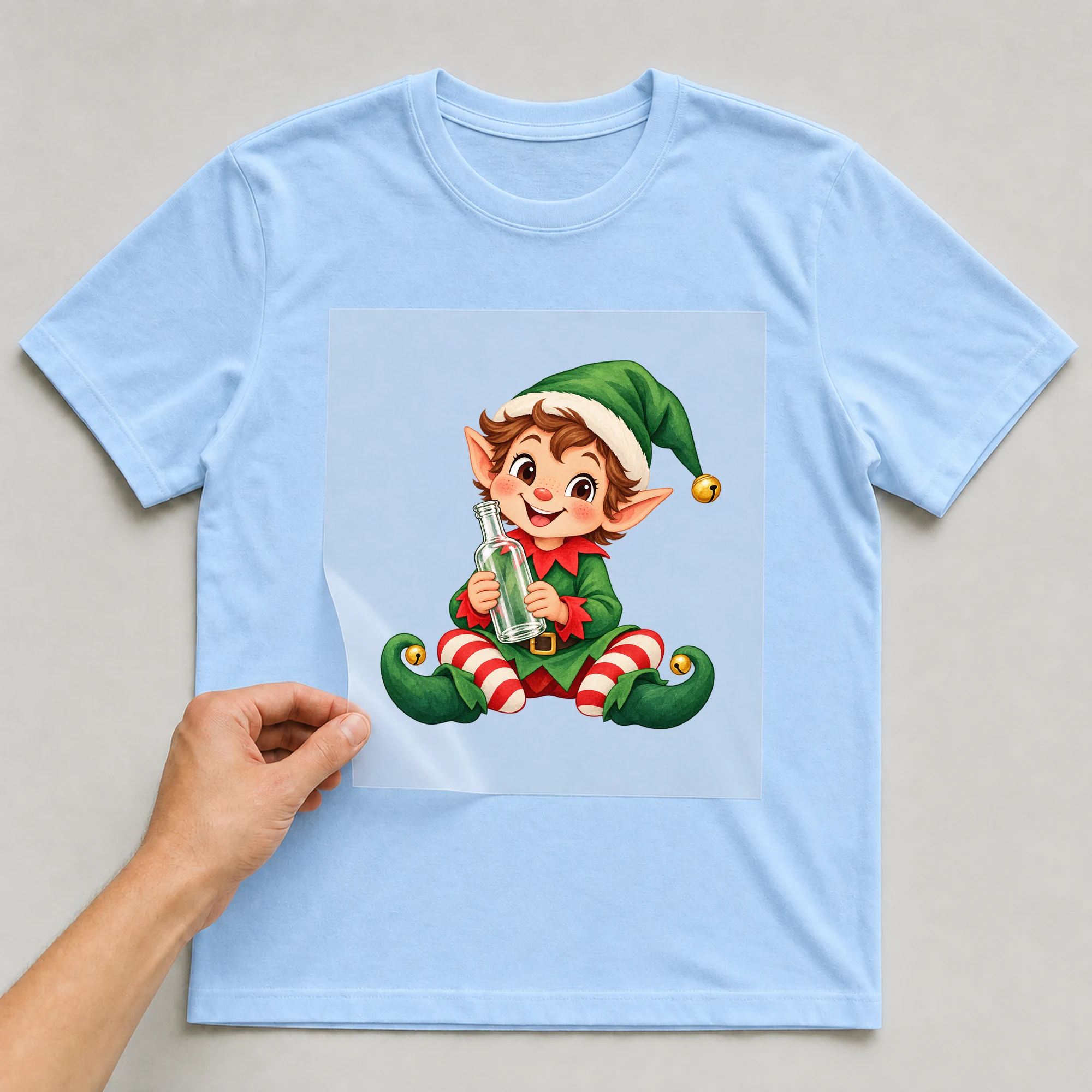 Bügelbild „Vodka Elf“ auf babyblauem T-Shirt, Folie wird aufgelegt
