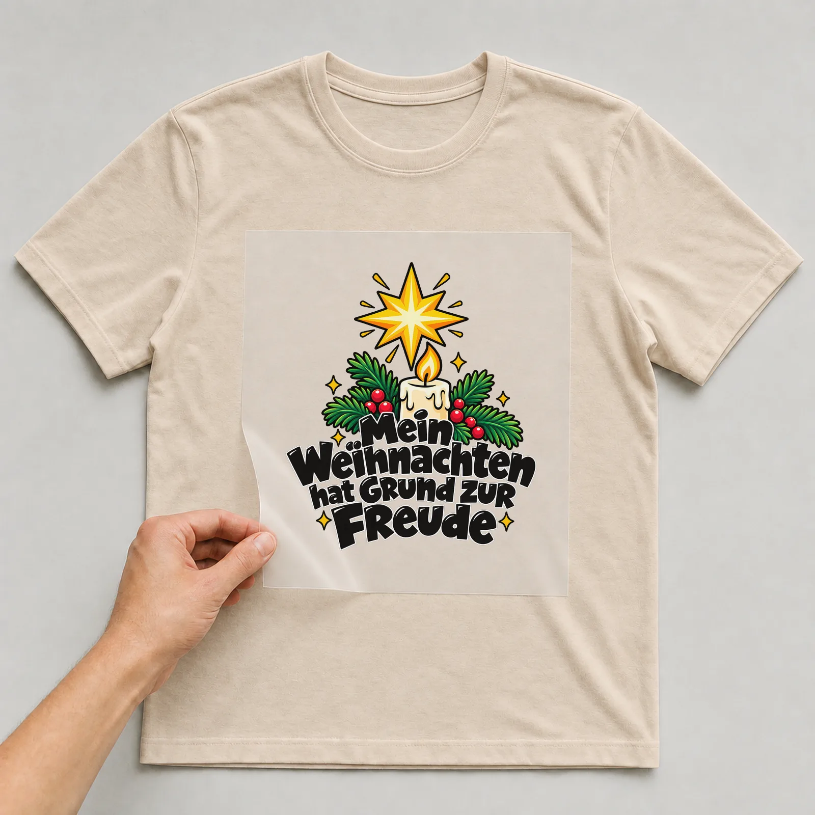 Bügelbild „Mein Weihnachten hat Grund zur Freude“ auf beigem T-Shirt, Folie wird aufgelegt
