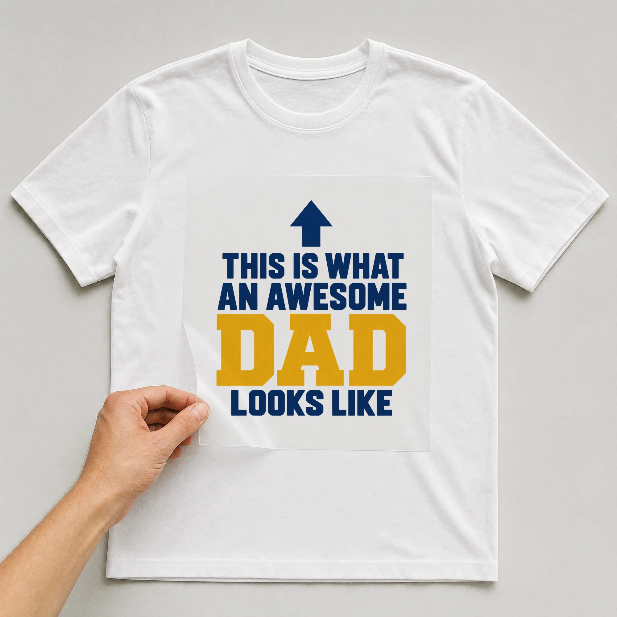 Bügelbild „This Is What An Awesome Dad Looks Like“ auf weißem T-Shirt, Folie wird aufgelegt