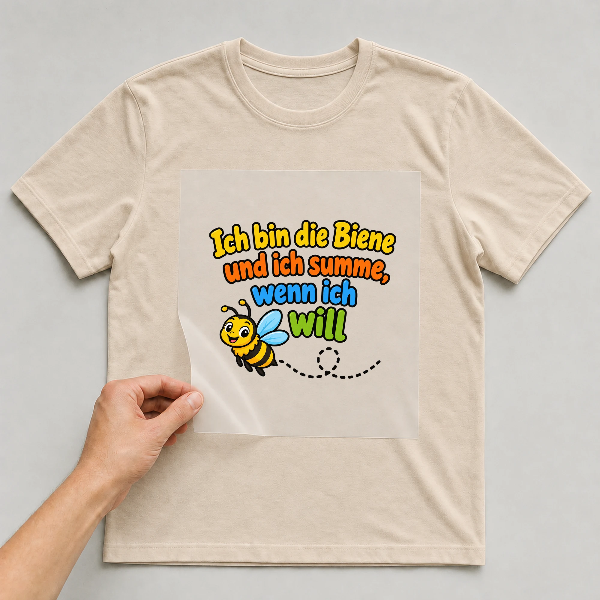 Bügelbild „Ich bin die Biene und ich summe, wenn ich will“ auf beigem T-Shirt, Folie wird aufgelegt