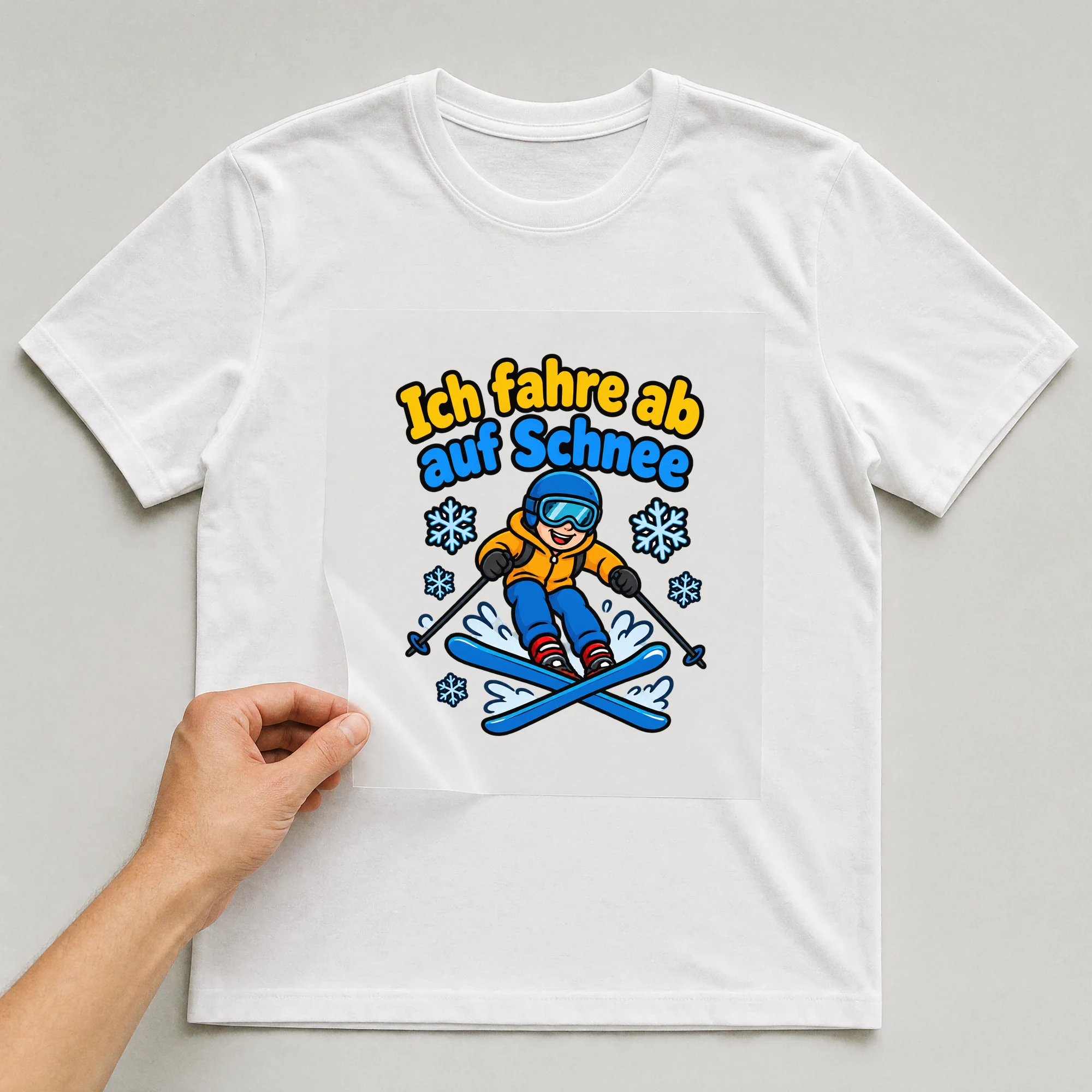 Bügelbild „Ich fahre ab auf Schnee“ auf weißem T-Shirt, Folie wird aufgelegt