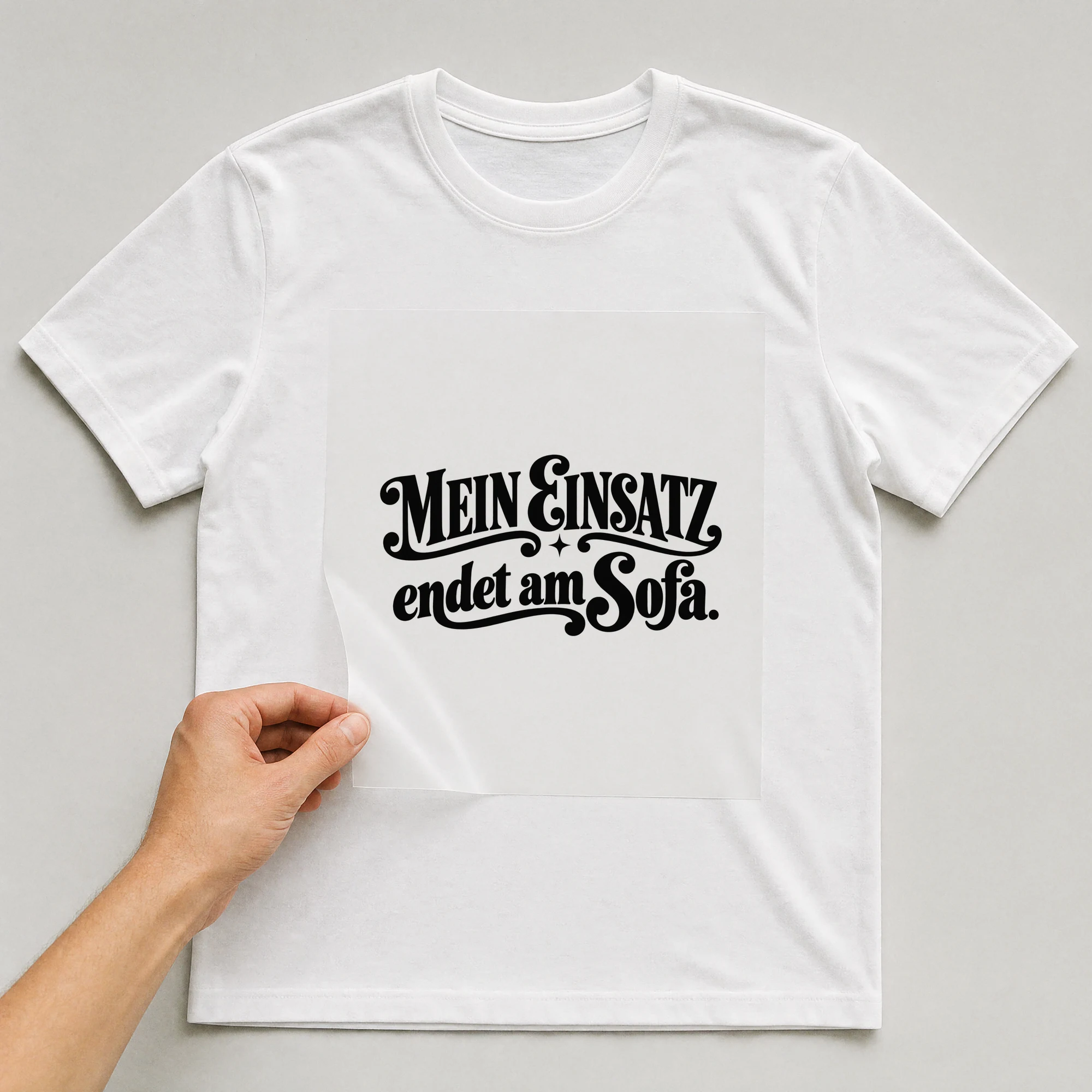 Bügelbild „Mein Einsatz endet am Sofa.“ auf weißem T-Shirt, Folie wird aufgelegt