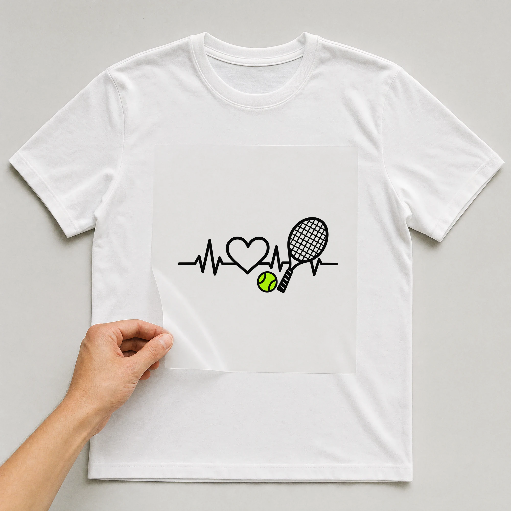 Bügelbild „Tennis Herzschlag“ auf weißem T-Shirt, Folie wird aufgelegt