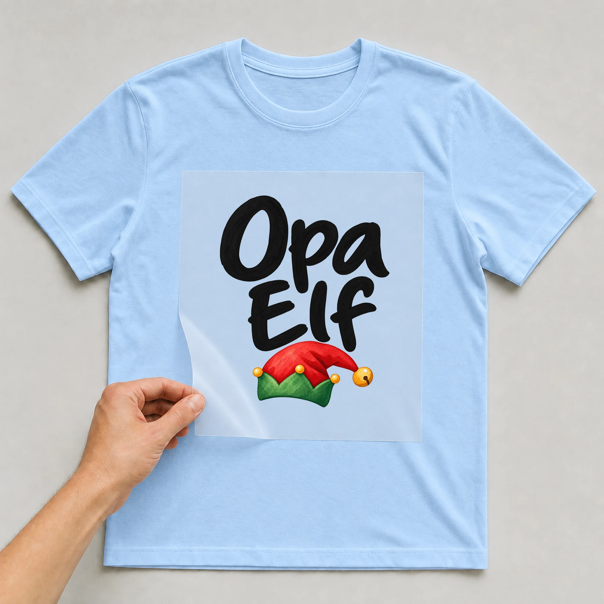 Bügelbild „Opa Elf“ auf babyblauem T-Shirt, Folie wird aufgelegt