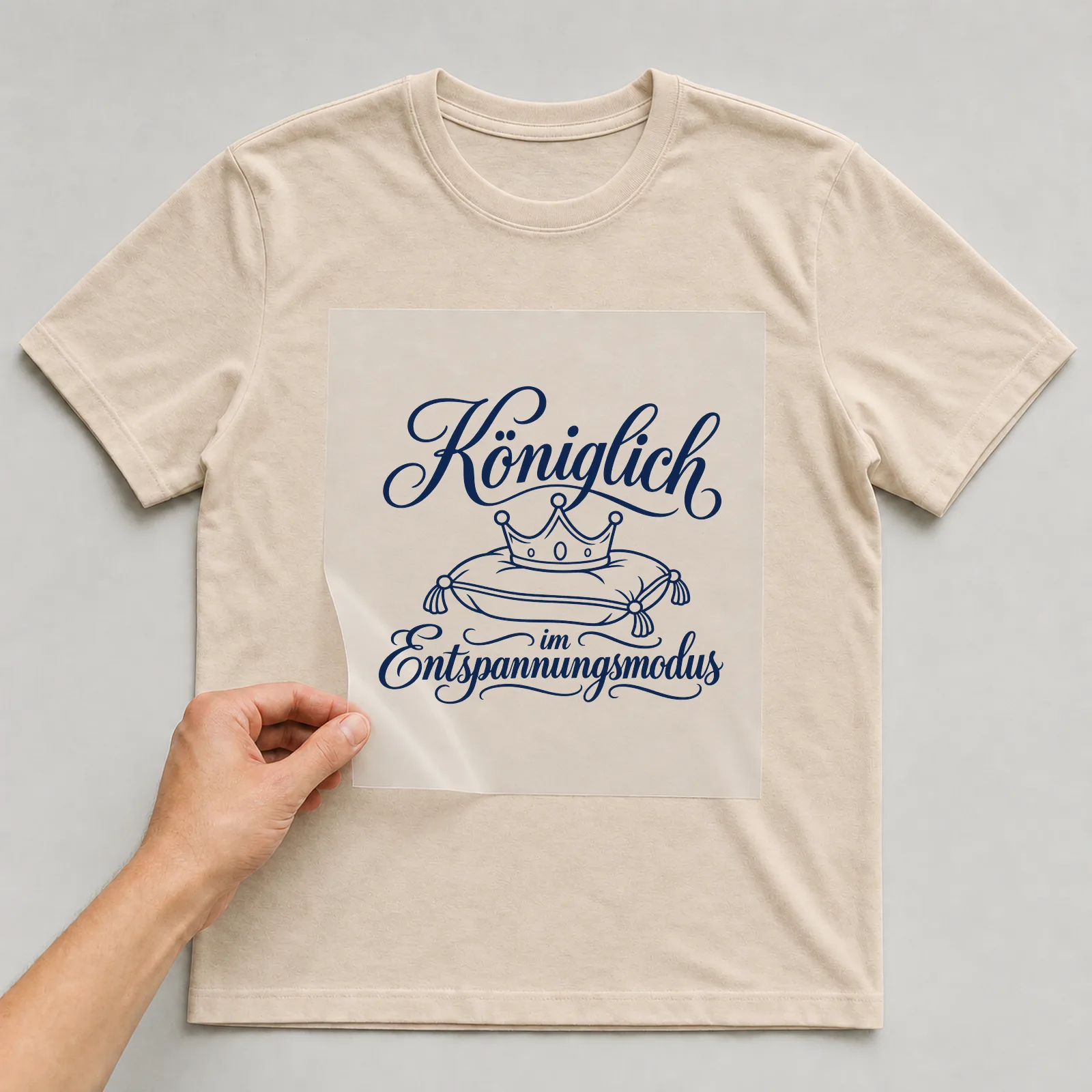 Bügelbild „Königlich im Entspannungsmodus“ auf beigem T-Shirt, Folie wird aufgelegt