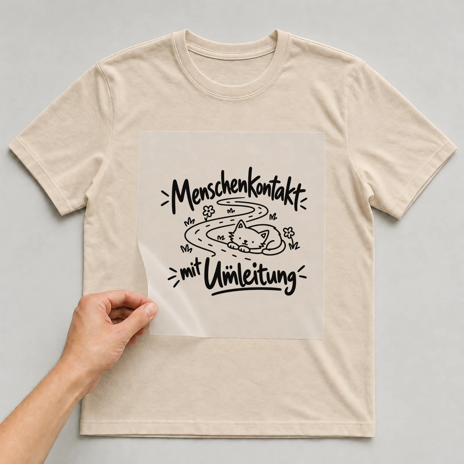 Bügelbild „Menschenkontakt mit Umleitung“ auf beigem T-Shirt, Folie wird aufgelegt