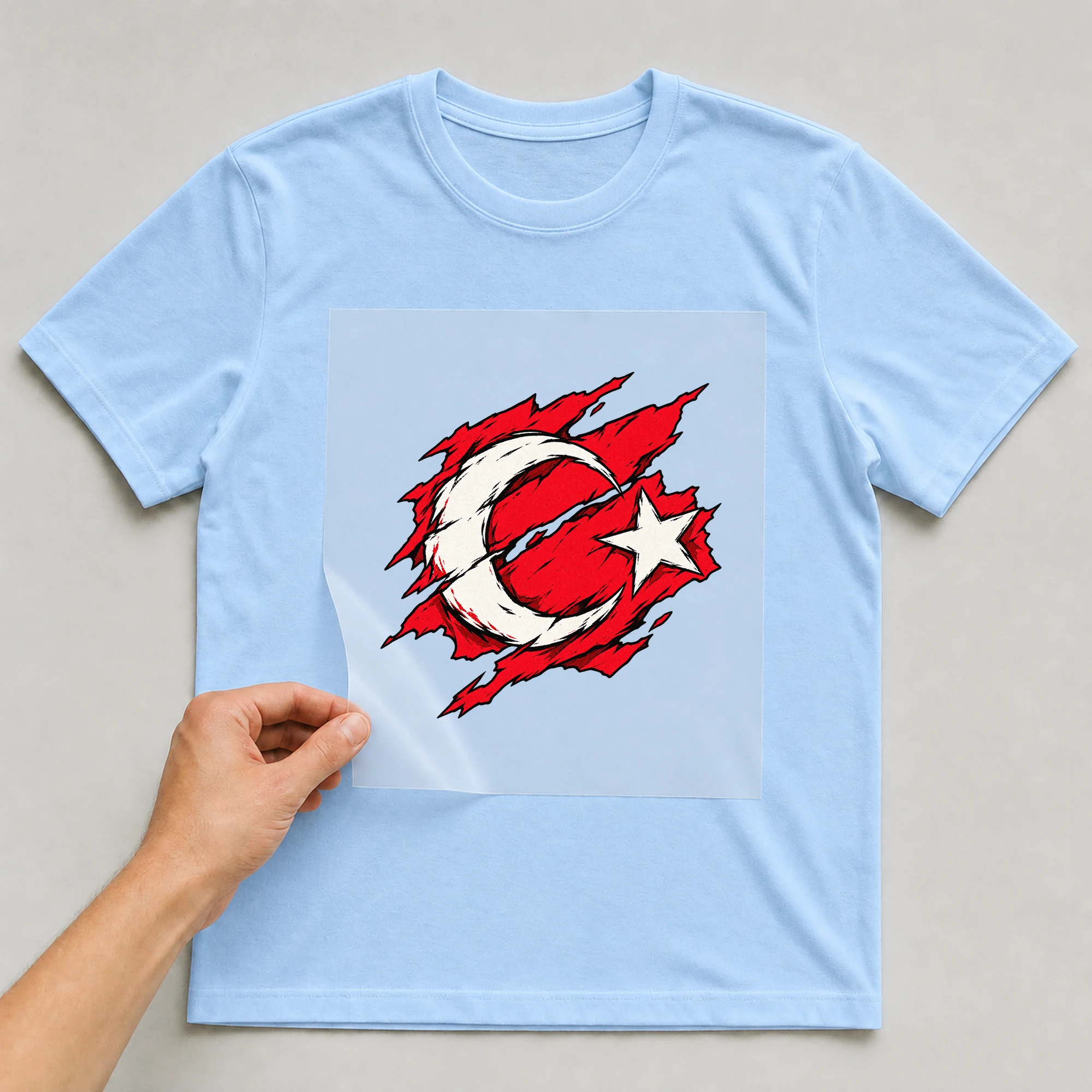 Bügelbild „Zerrissene Fahne Türkei“ auf babyblauem T-Shirt, Folie wird aufgelegt