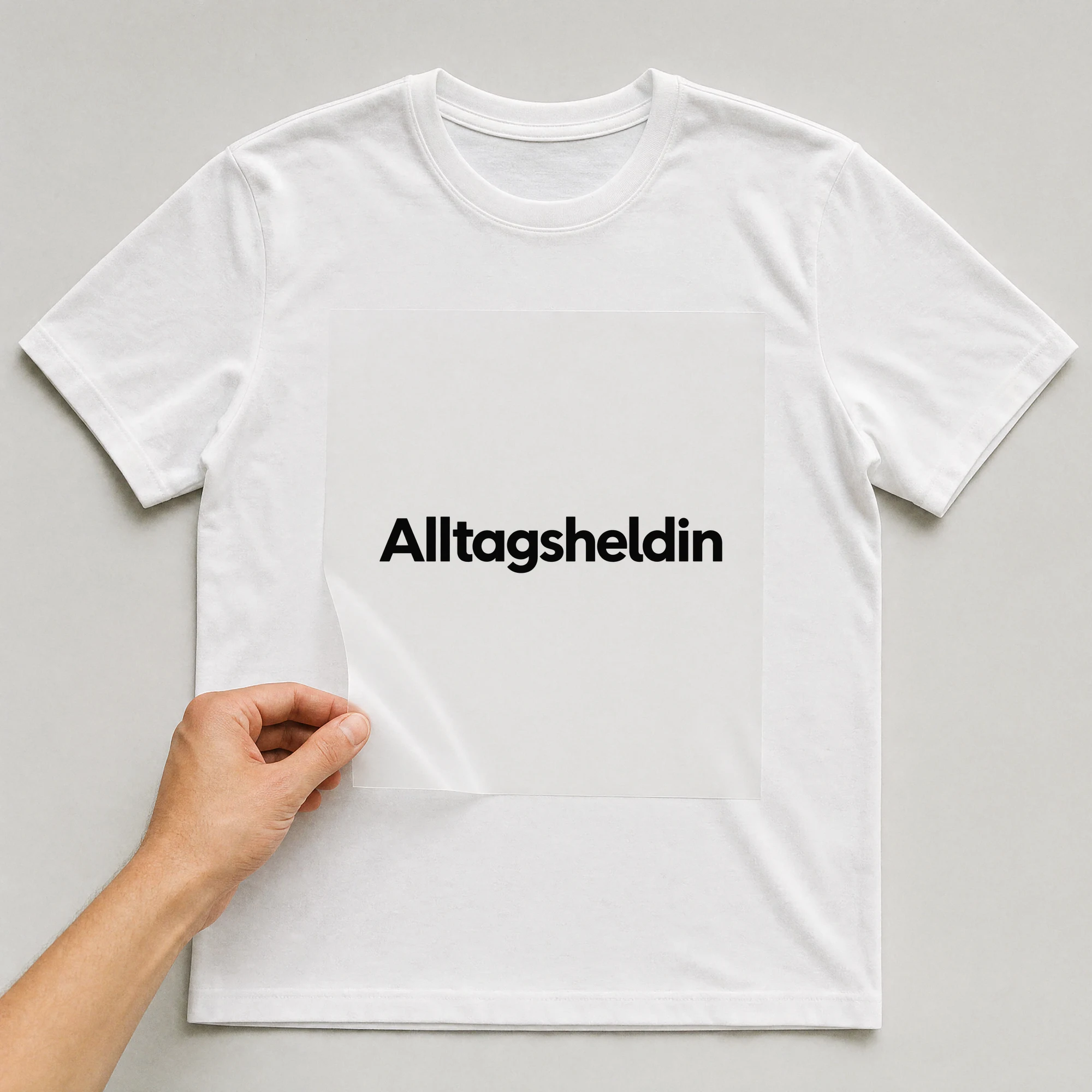 Bügelbild „Alltagsheldin“ auf weißem T-Shirt, Folie wird aufgelegt