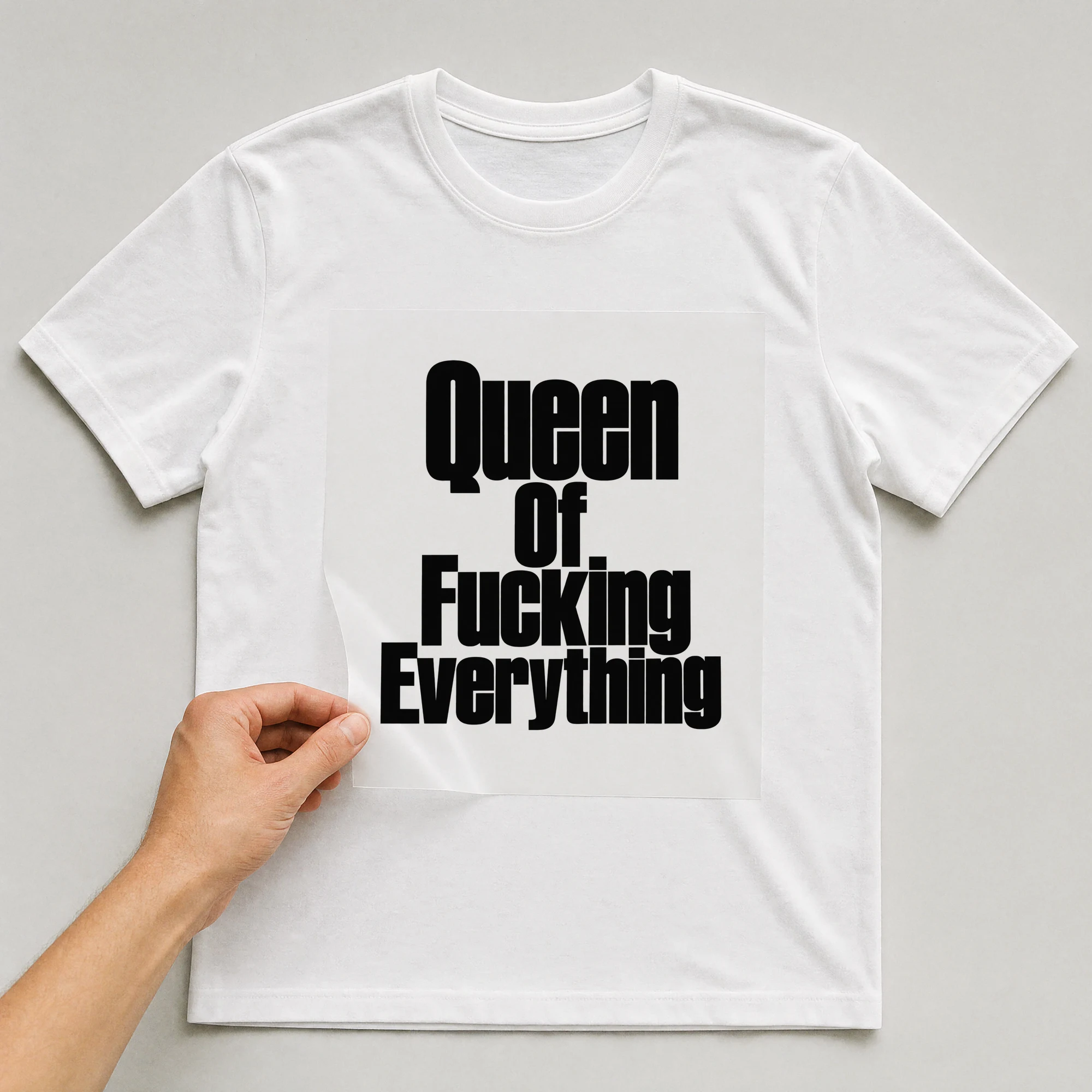 Bügelbild „Queen Of F*cking Everything“ auf weißem T-Shirt, Folie wird aufgelegt