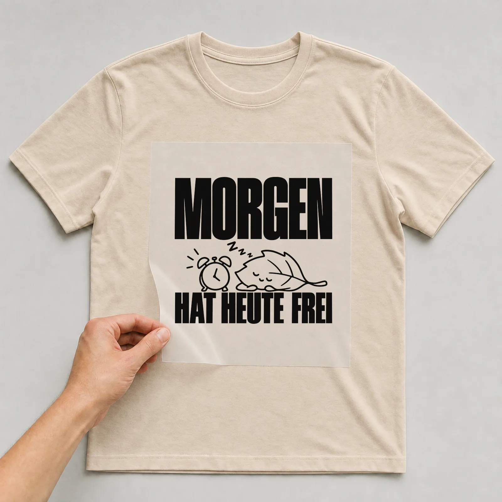 Bügelbild „Morgen hat heute frei“ auf beigem T-Shirt, Folie wird aufgelegt