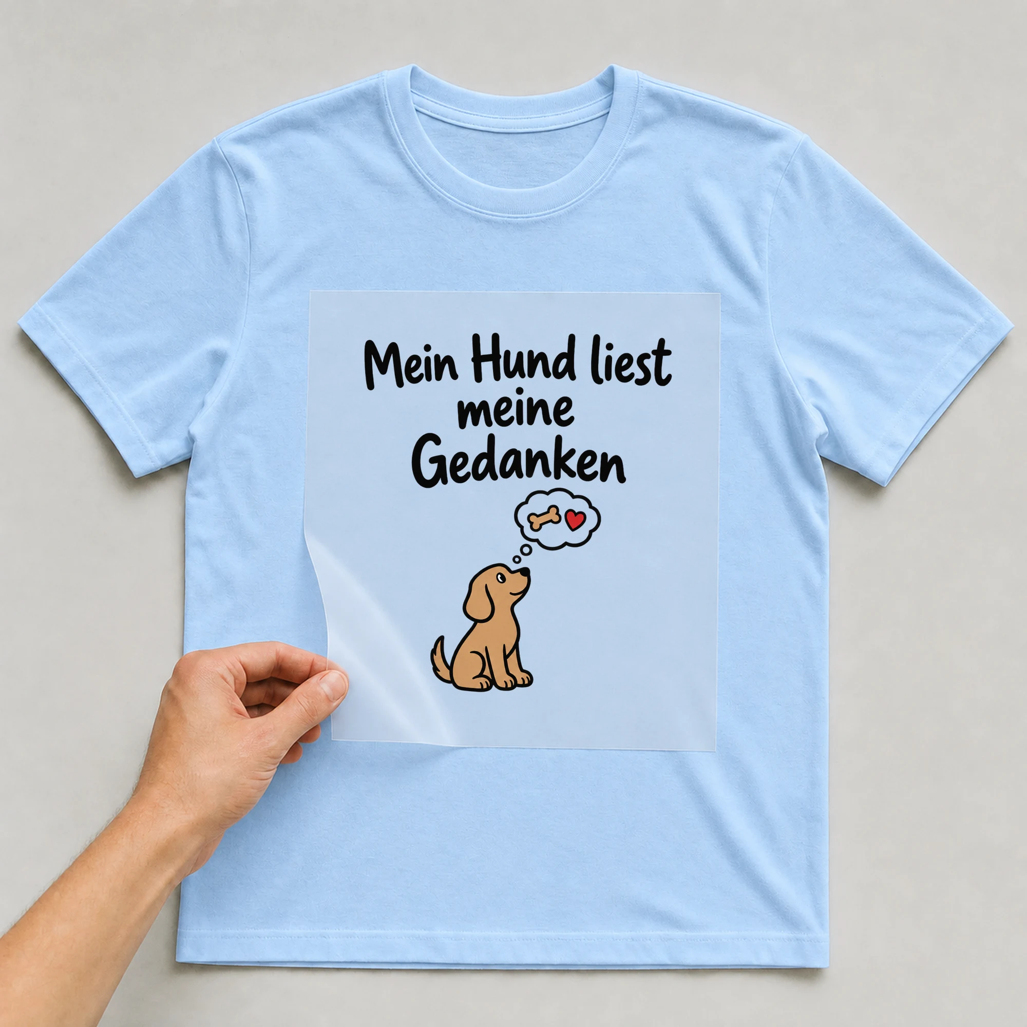 Bügelbild „Mein Hund liest meine Gedanken“ auf babyblauem T-Shirt, Folie wird aufgelegt