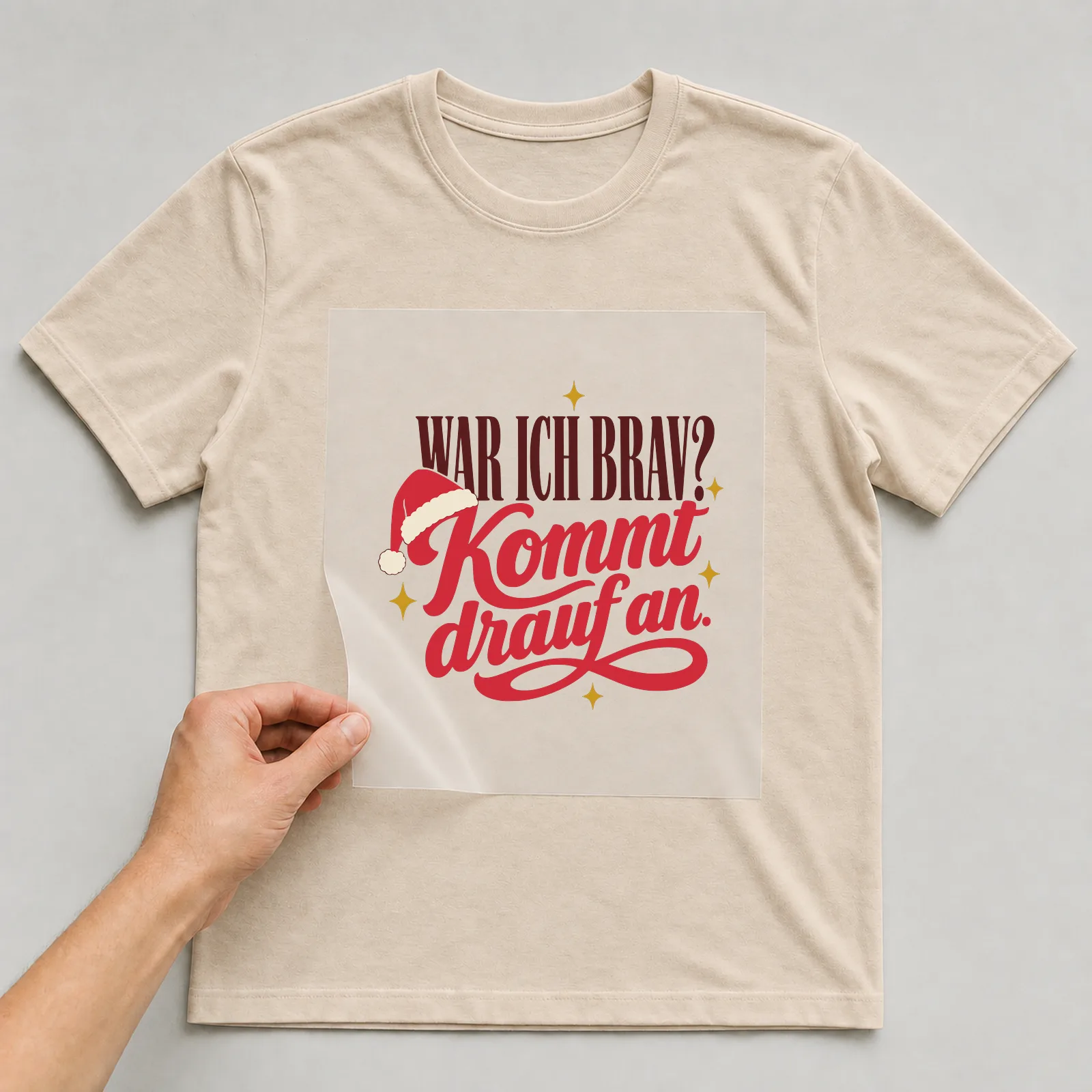 Bügelbild War ich brav? Kommt drauf an. auf beigem T-Shirt, Folie wird aufgelegt