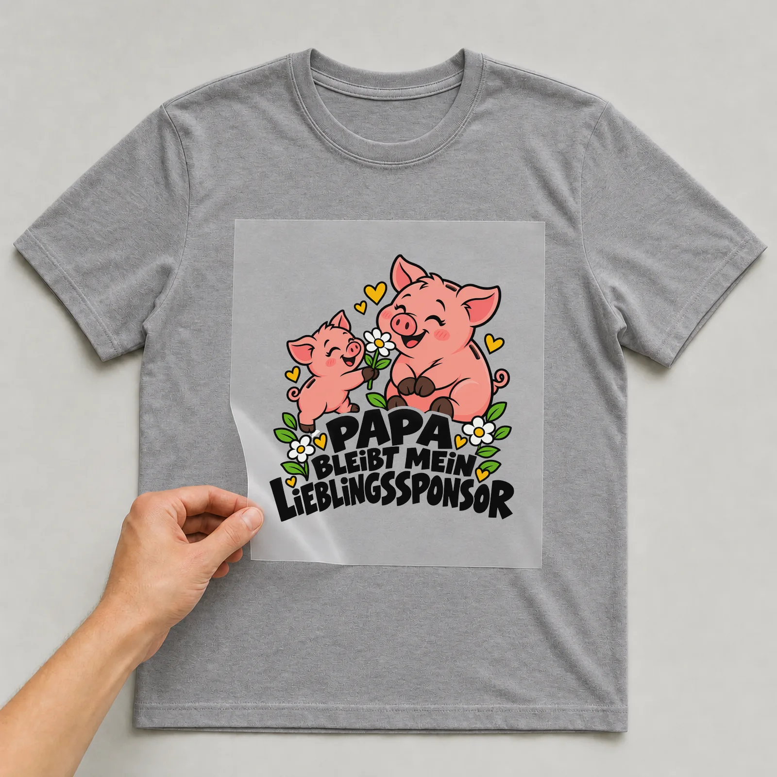 Bügelbild „Papa bleibt mein Lieblingssponsor“ auf grauem T-Shirt, Folie wird aufgelegt