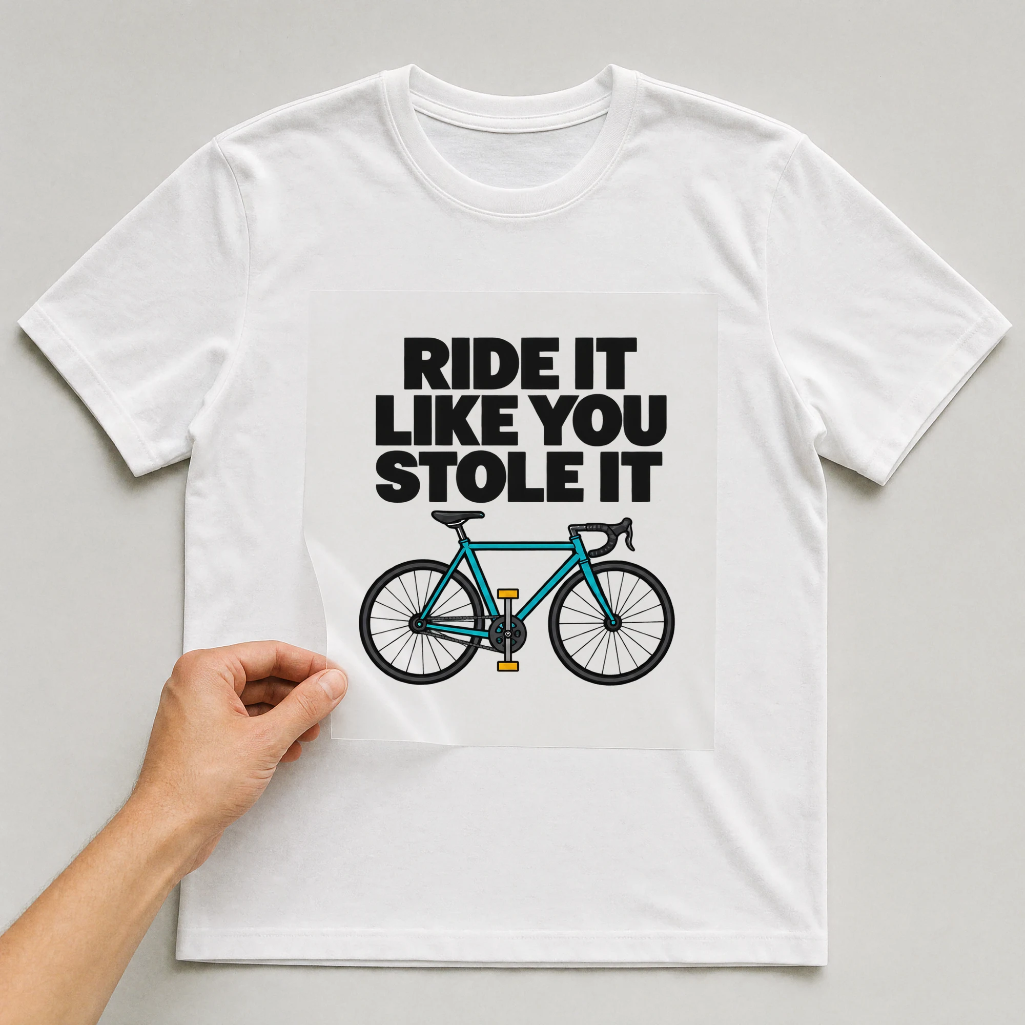 Bügelbild „RIDE IT LIKE YOU STOLE IT“ auf weißem T-Shirt, Folie wird aufgelegt