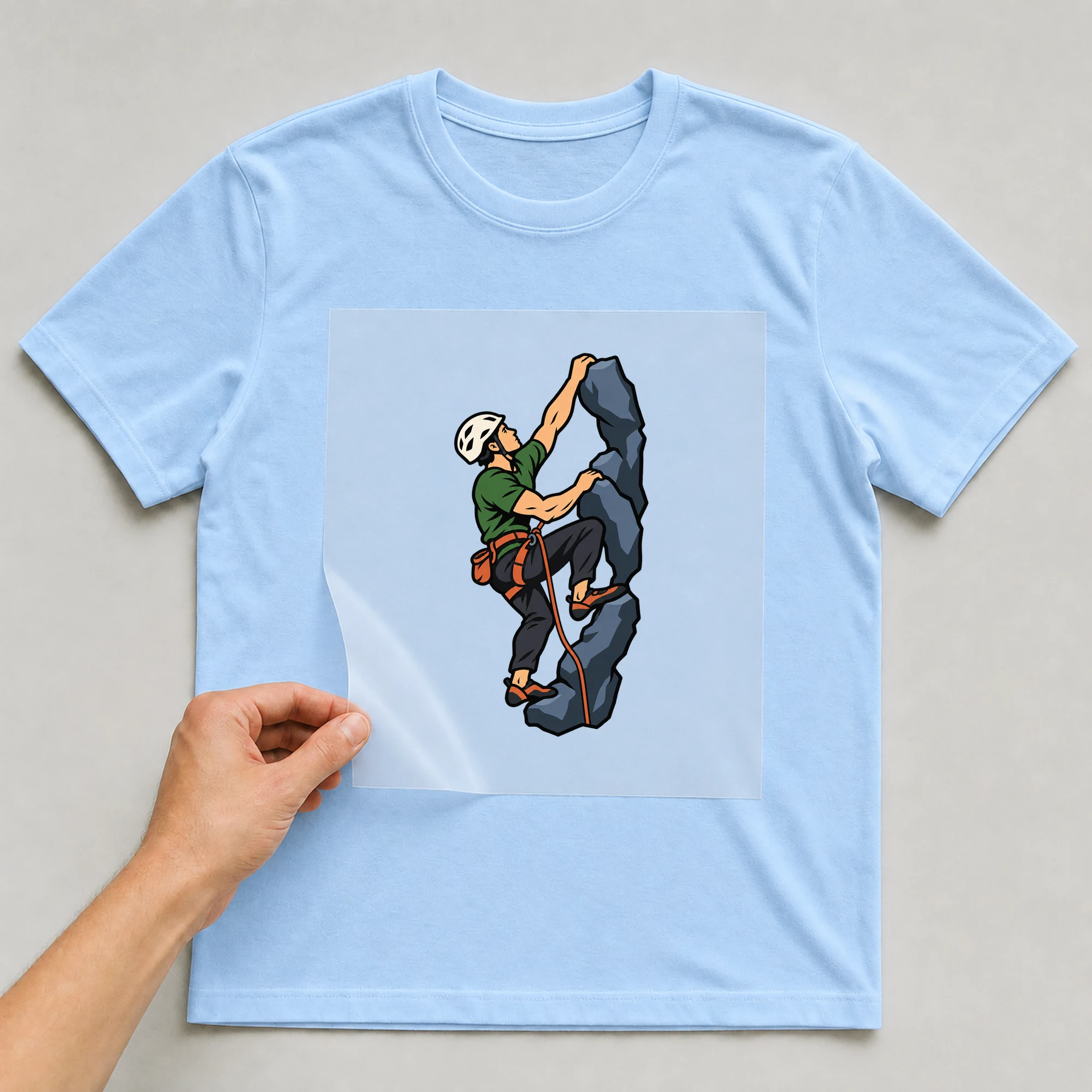 Bügelbild „Retro Kletterer Mann“ auf babyblauem T-Shirt, Folie wird aufgelegt