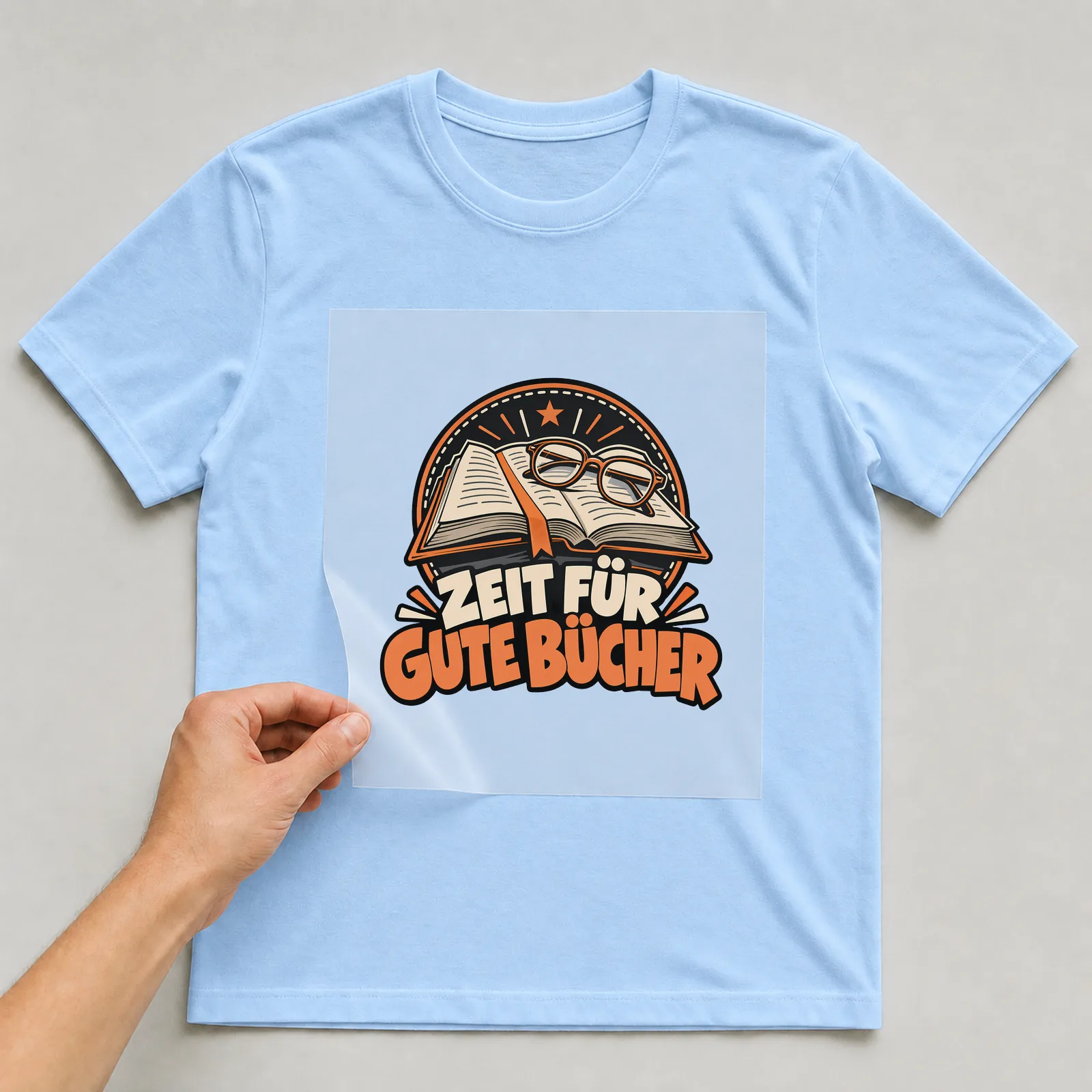 Bügelbild „Zeit für gute Bücher“ auf hellblauem T-Shirt, Folie wird aufgelegt