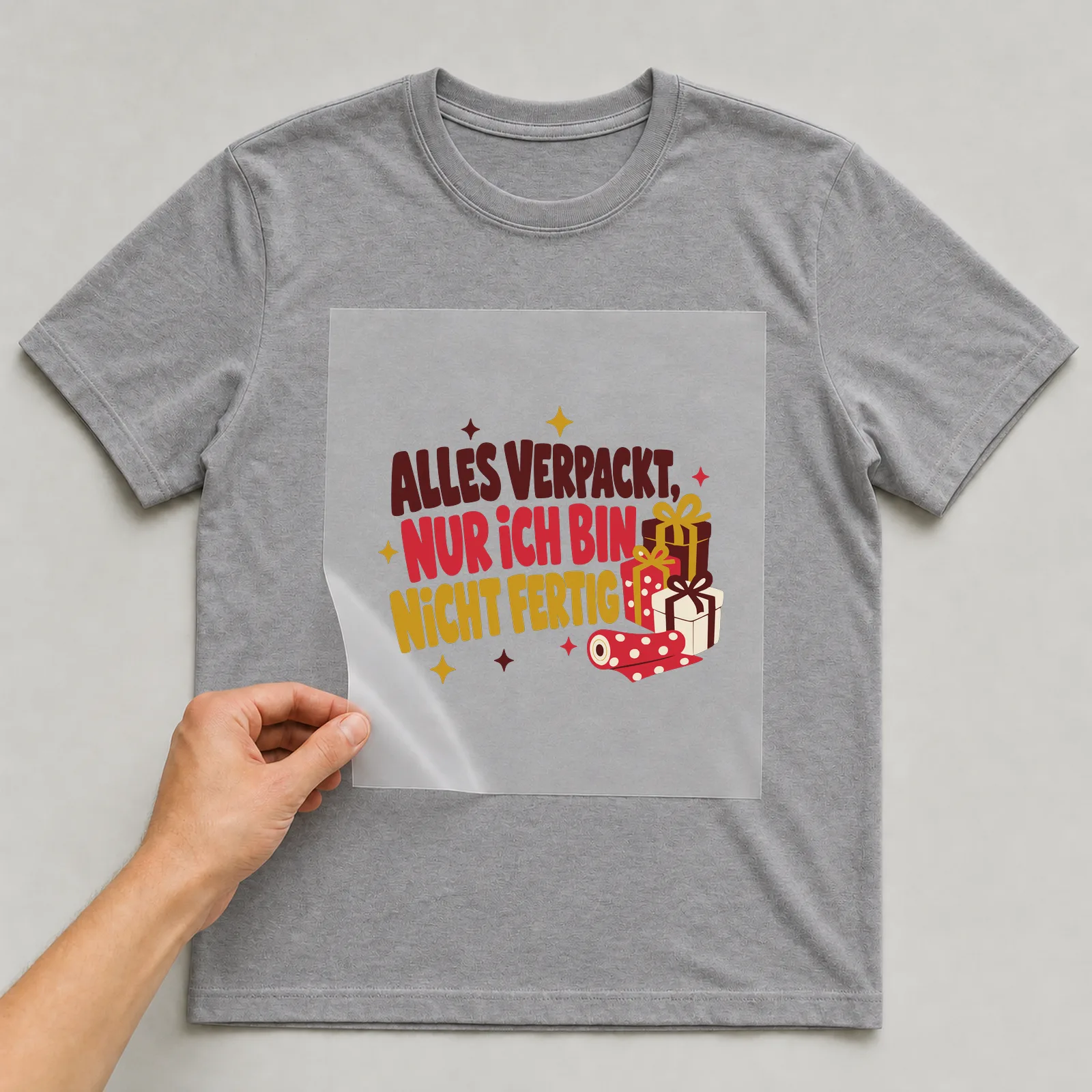 Bügelbild Alles verpackt, nur ich bin nicht fertig auf grauem T-Shirt, Folie wird aufgelegt