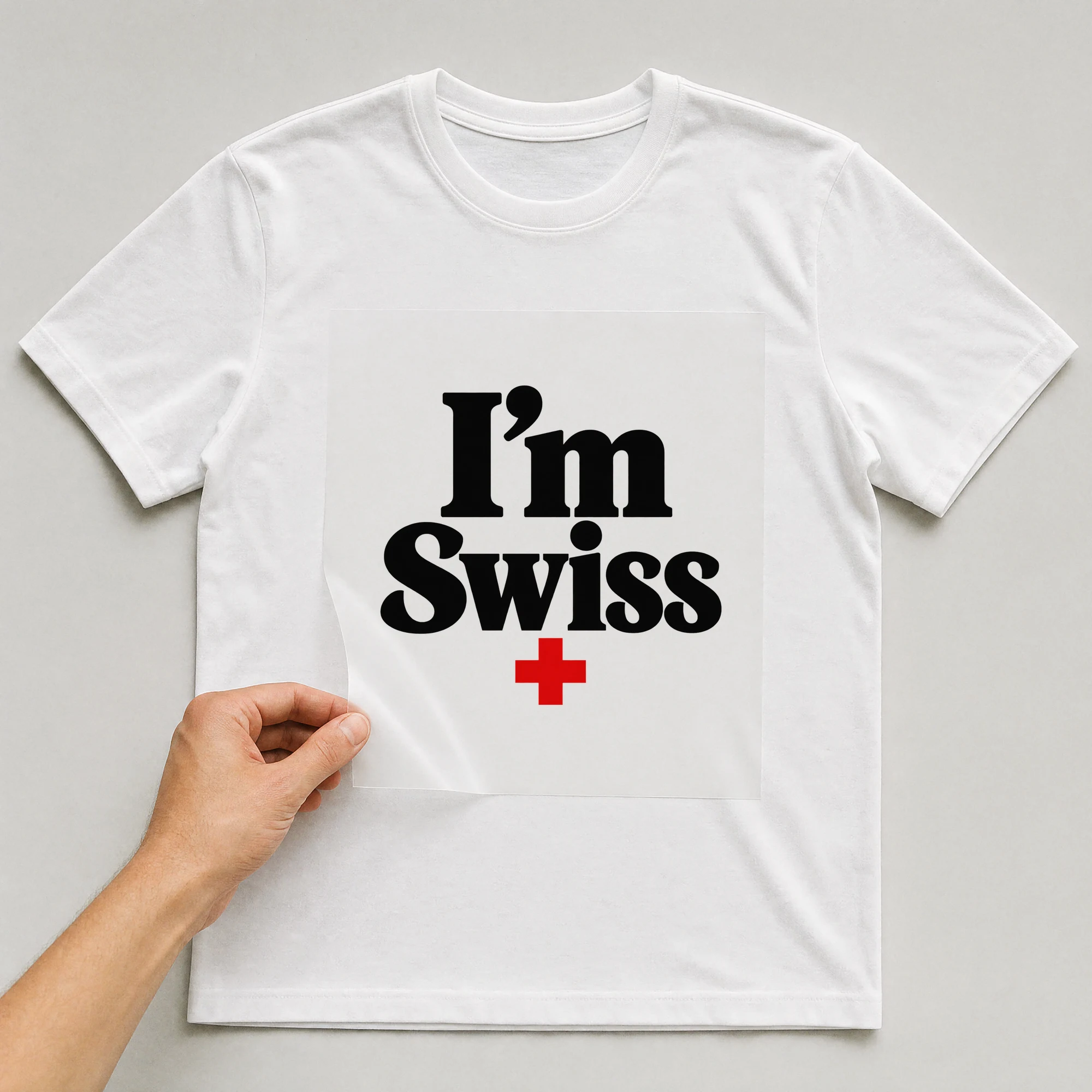 Bügelbild „I'm Swiss“ auf weißem T-Shirt, Folie wird aufgelegt