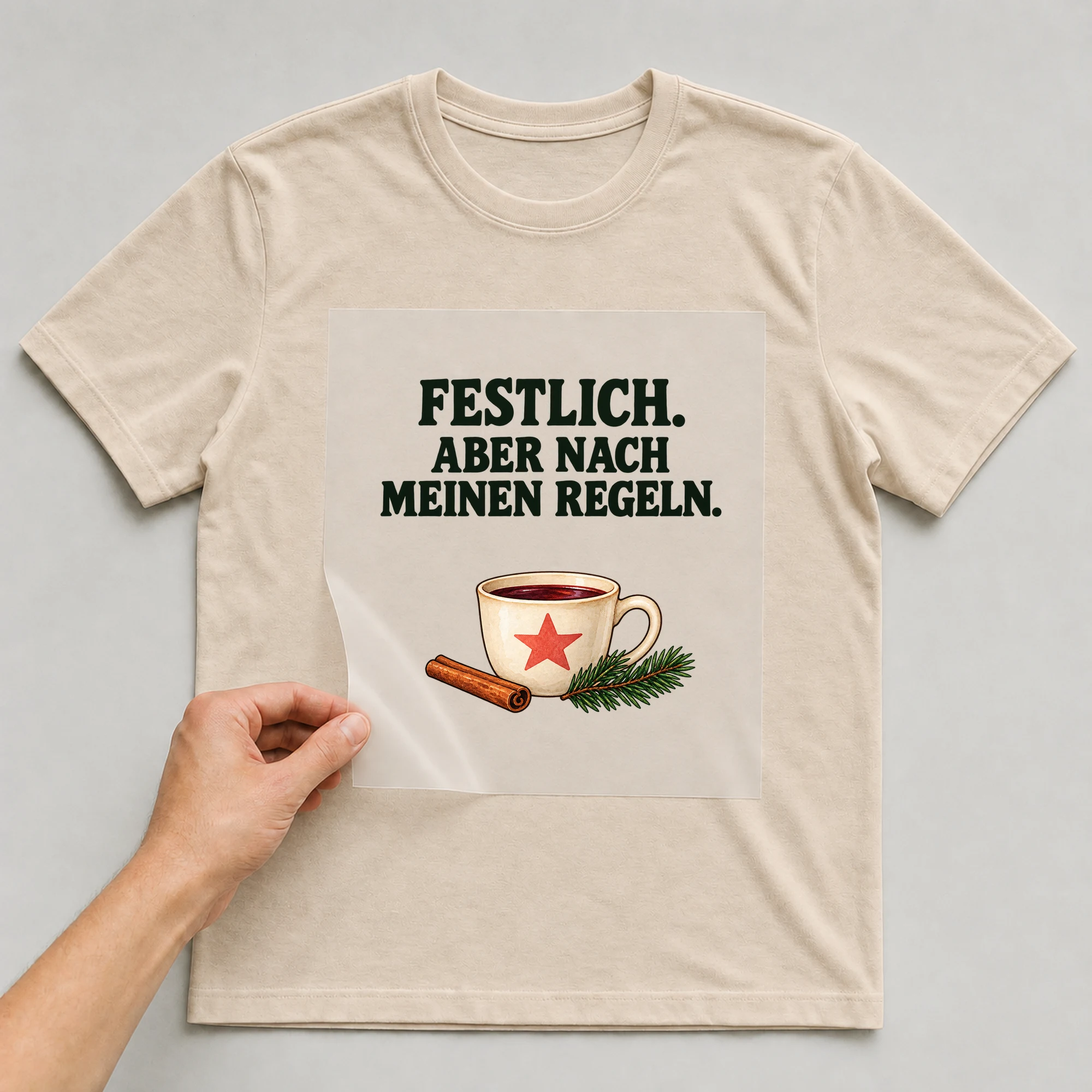 Bügelbild „FESTLICH. ABER NACH MEINEN REGELN.“ auf beigem T-Shirt, Folie wird aufgelegt