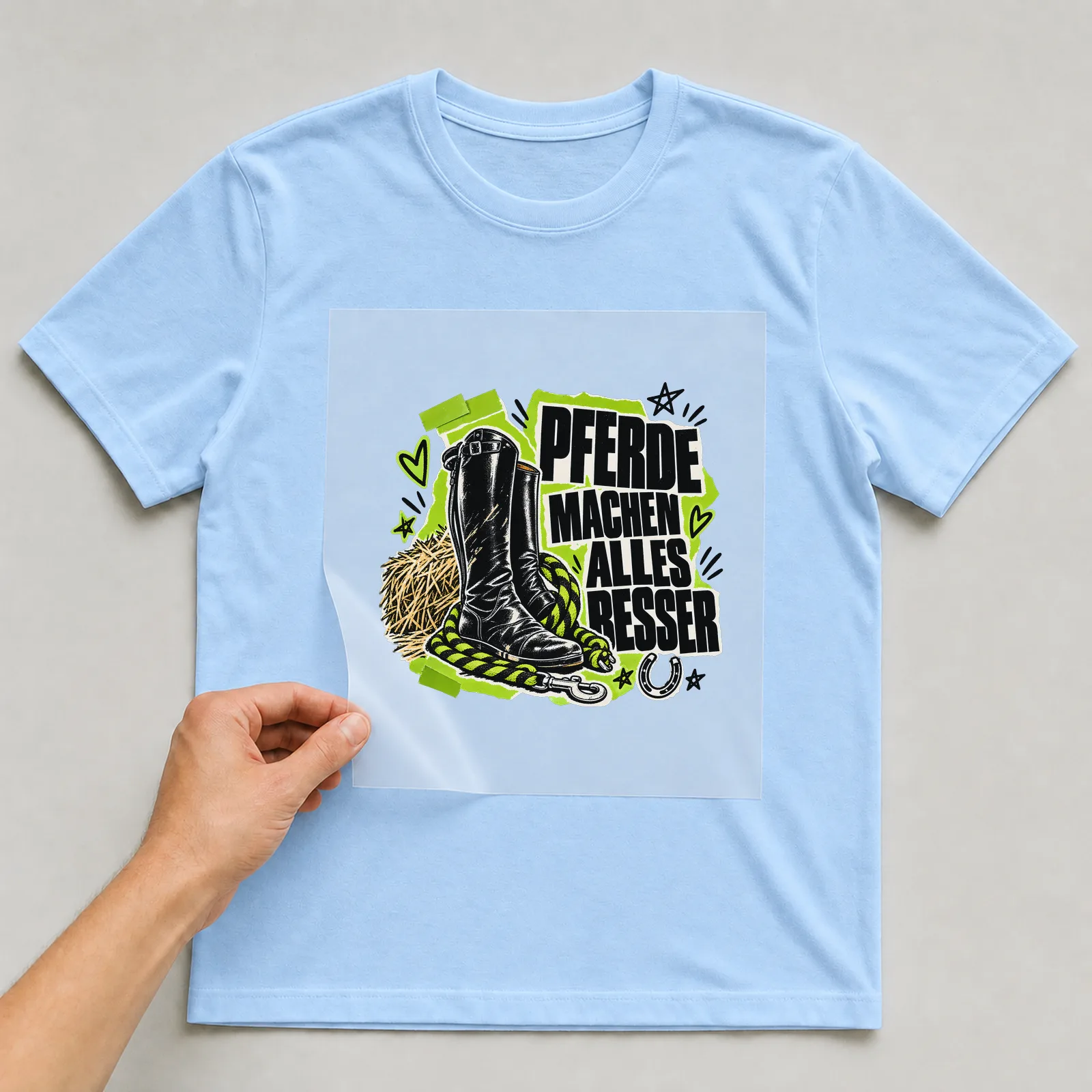 Bügelbild „Pferde machen alles besser“ auf hellblauem T-Shirt, Folie wird aufgelegt