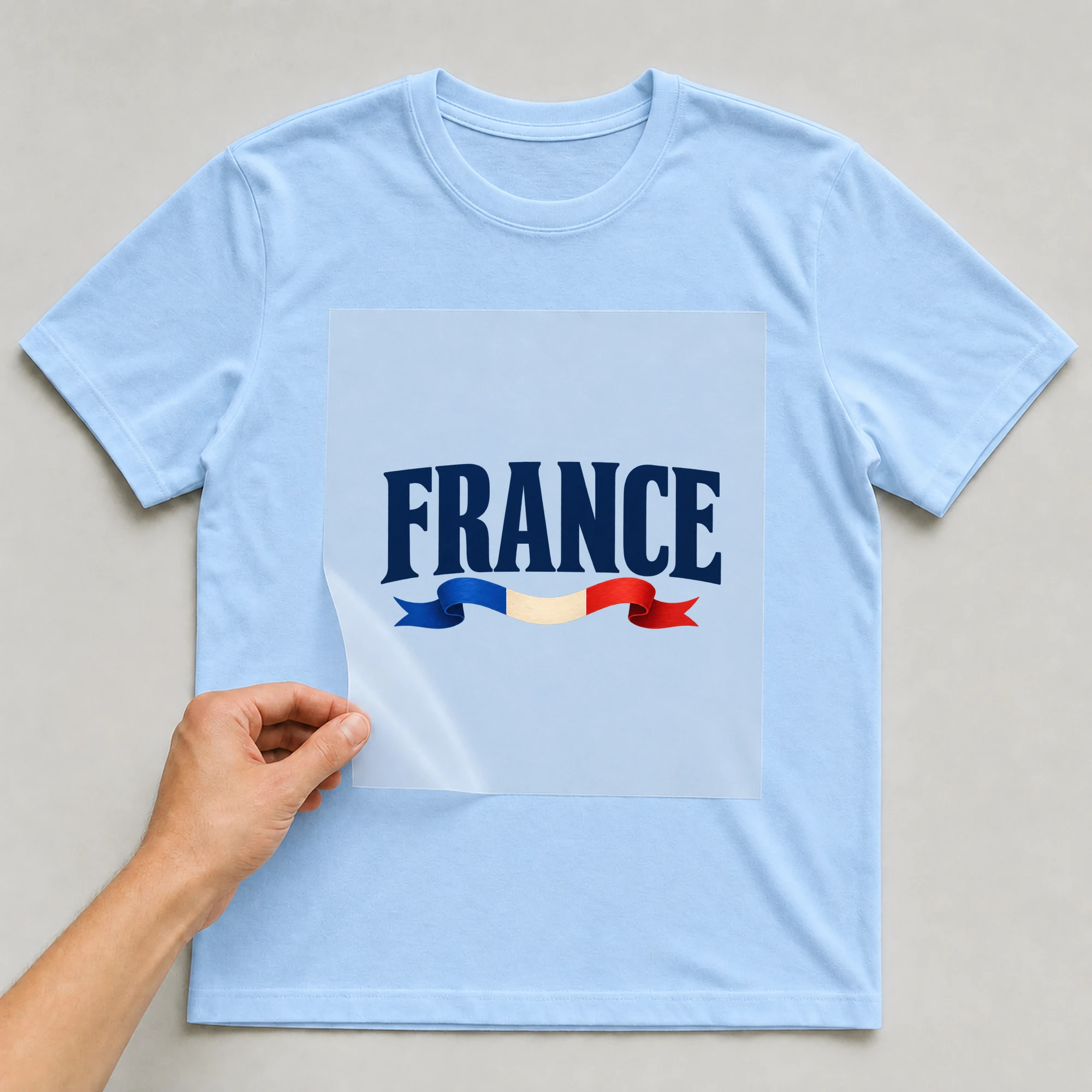 Bügelbild „France“ auf babyblauem T-Shirt, Folie wird aufgelegt