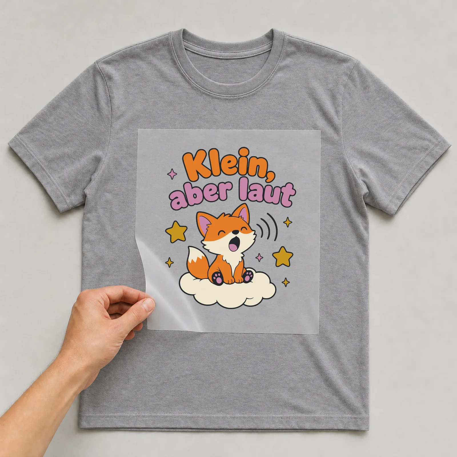 Bügelbild Klein, aber laut auf grauem T-Shirt, Folie wird aufgelegt