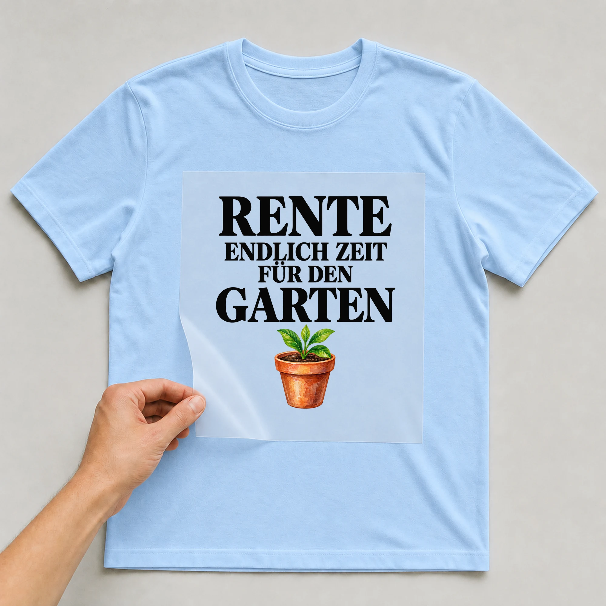 Bügelbild „Rente endlich Zeit für den Garten“ auf babyblauem T-Shirt, Folie wird aufgelegt