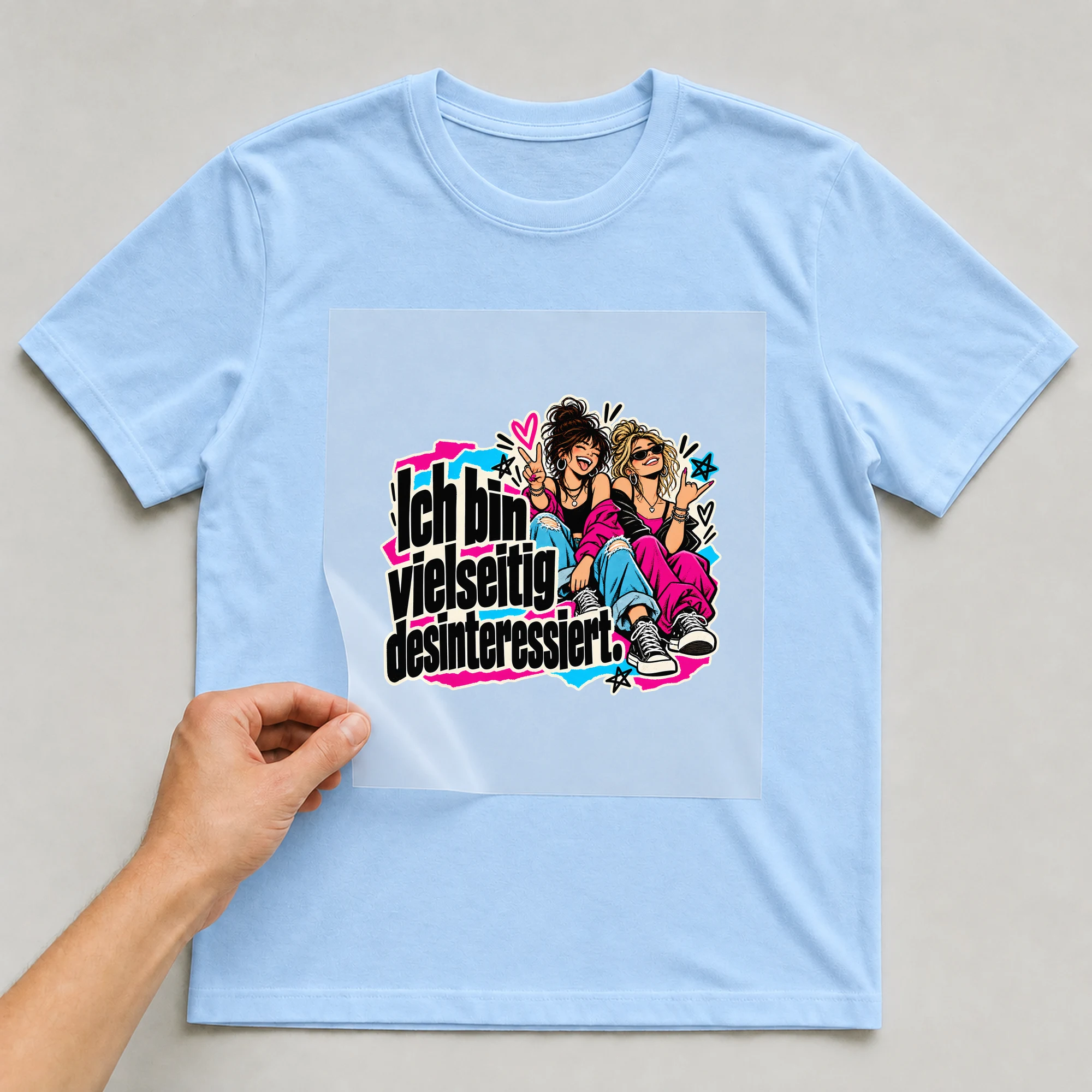 Bügelbild „Ich bin vielseitig desinteressiert.“ auf babyblauem T-Shirt, Folie wird aufgelegt