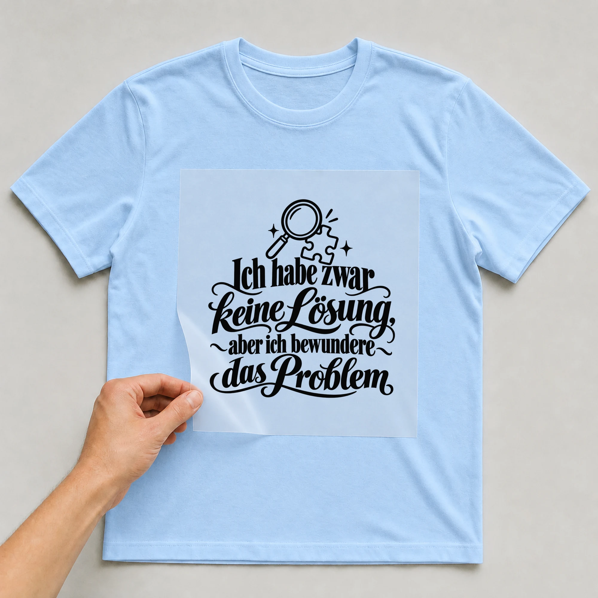 Bügelbild „Ich habe keine Lösung, aber ich bewundere das Problem“ auf babyblauem T-Shirt, Folie wird aufgelegt