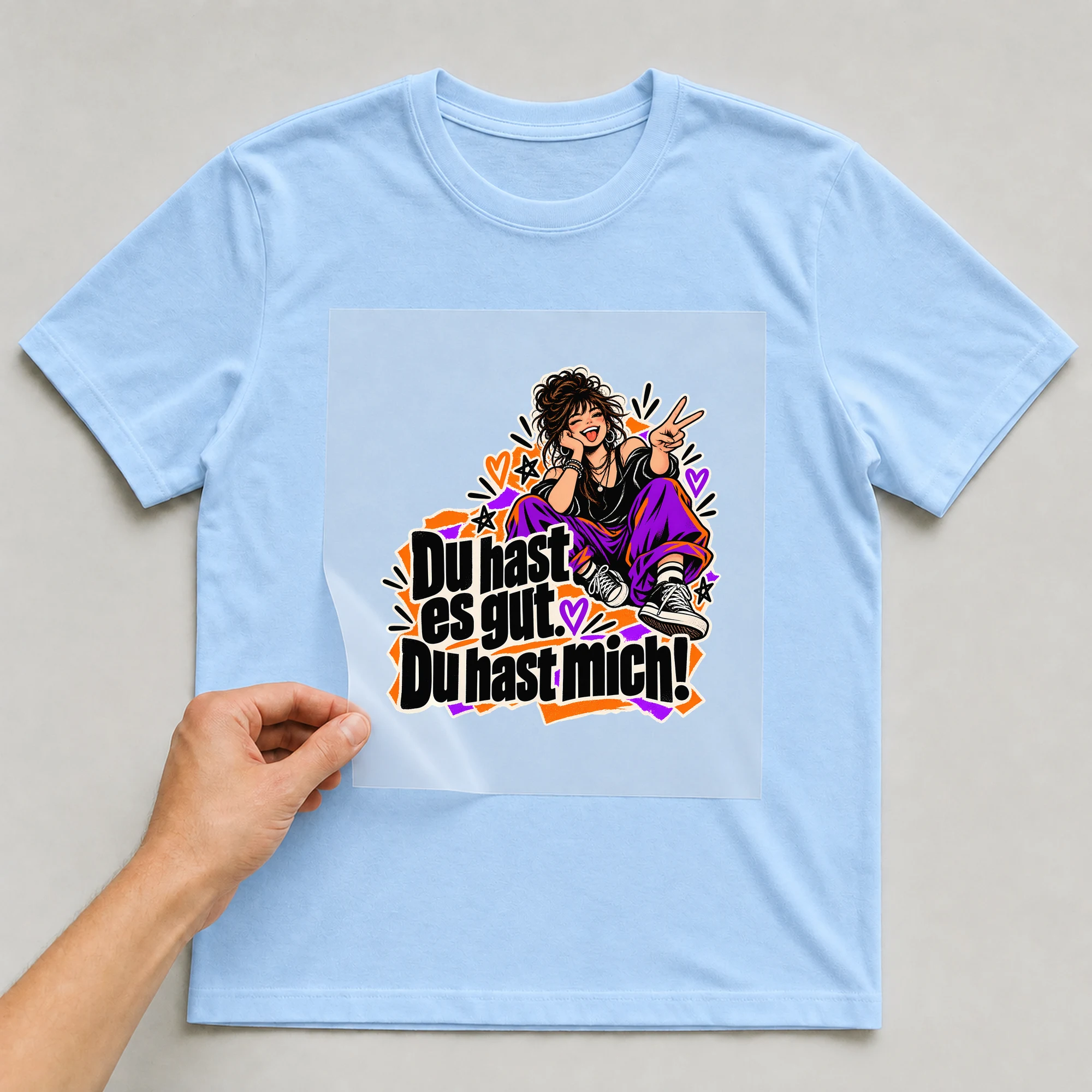 Bügelbild „Du hast es gut. Du hast mich!“ auf babyblauem T-Shirt, Folie wird aufgelegt