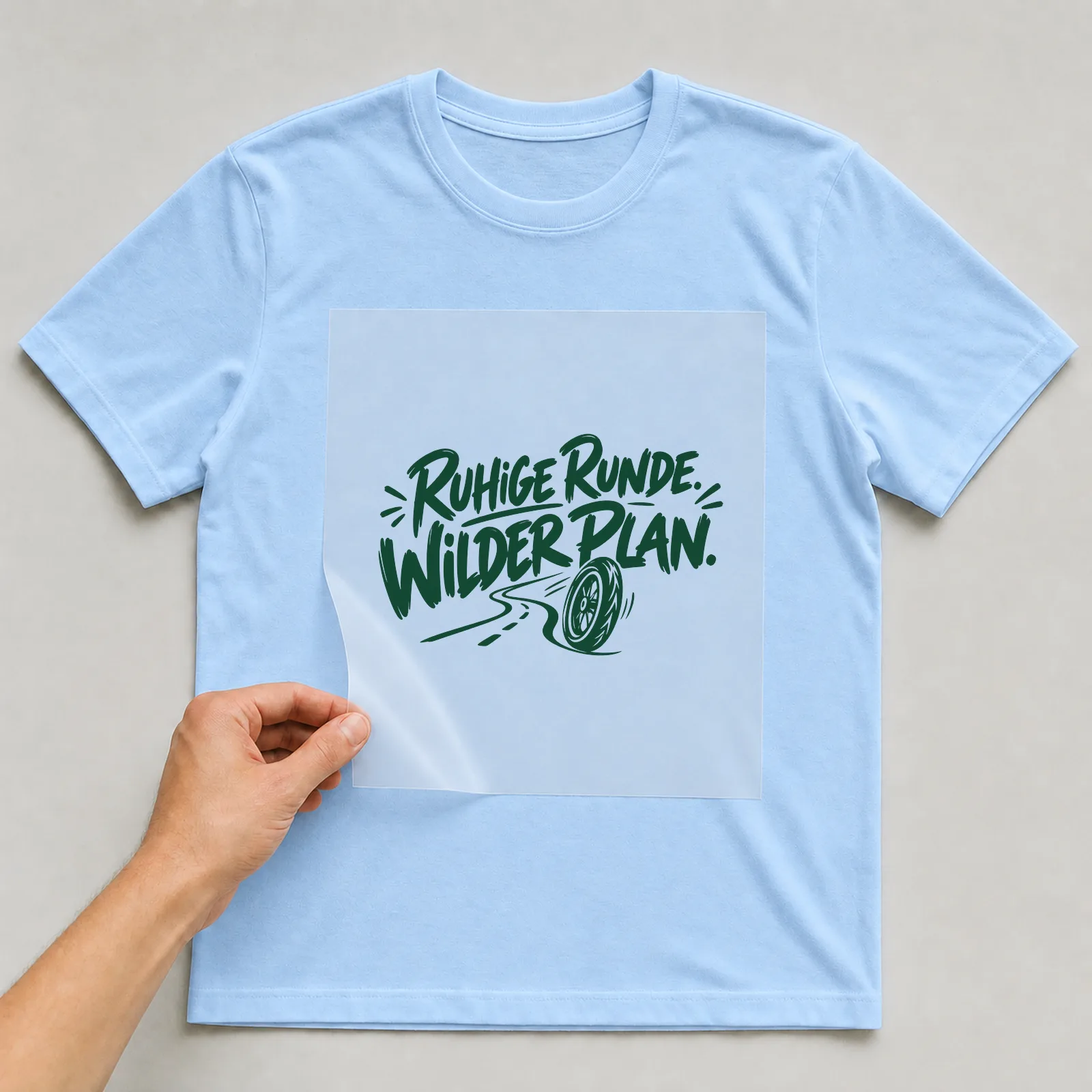 Bügelbild „Ruhige Runde. Wilder Plan.“ auf hellblauem T-Shirt, Folie wird aufgelegt