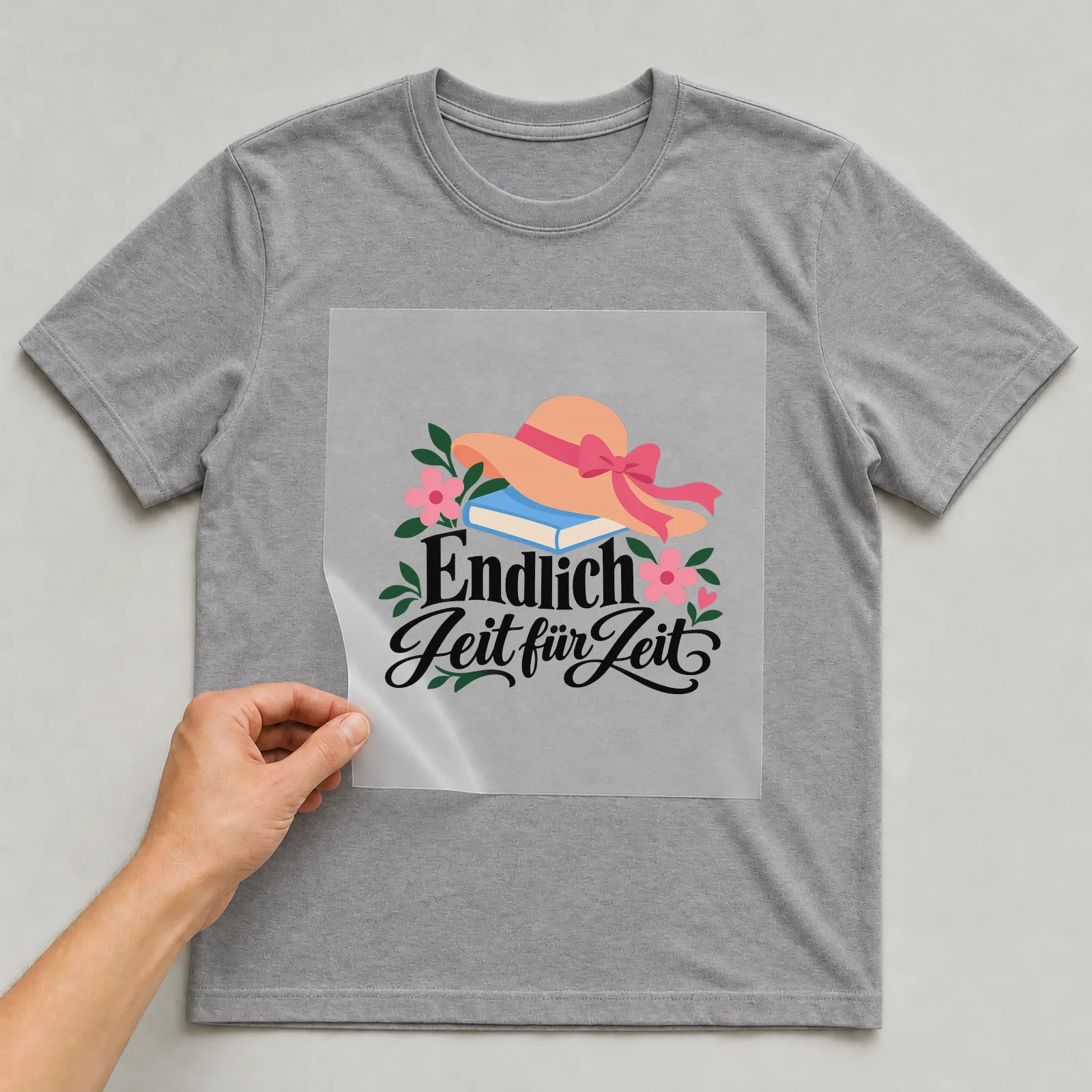 Bügelbild „Endlich Zeit für Zeit“ auf grauem T-Shirt, Folie wird aufgelegt