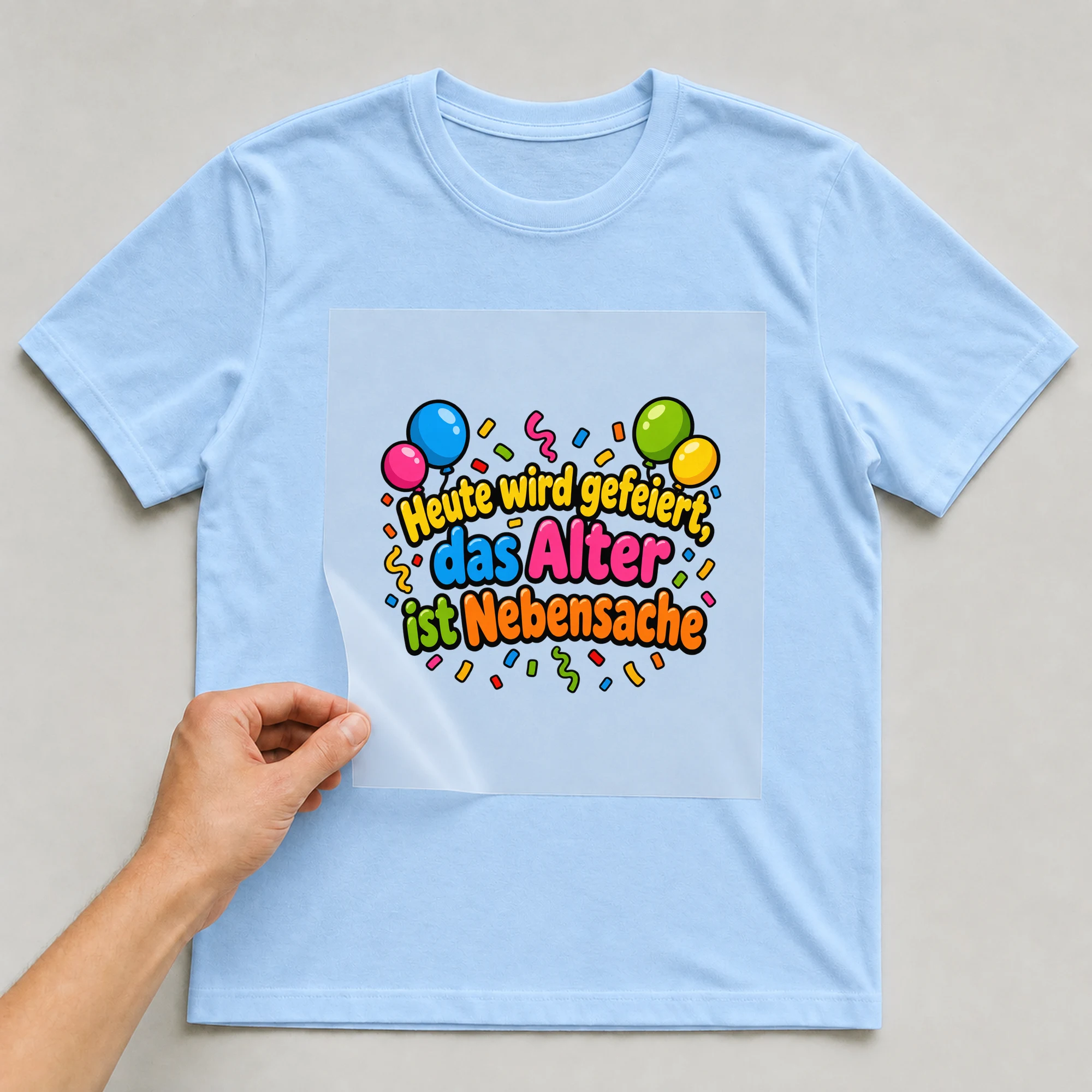 Bügelbild „Heute wird gefeiert das alter ist“ auf babyblauem T-Shirt, Folie wird aufgelegt