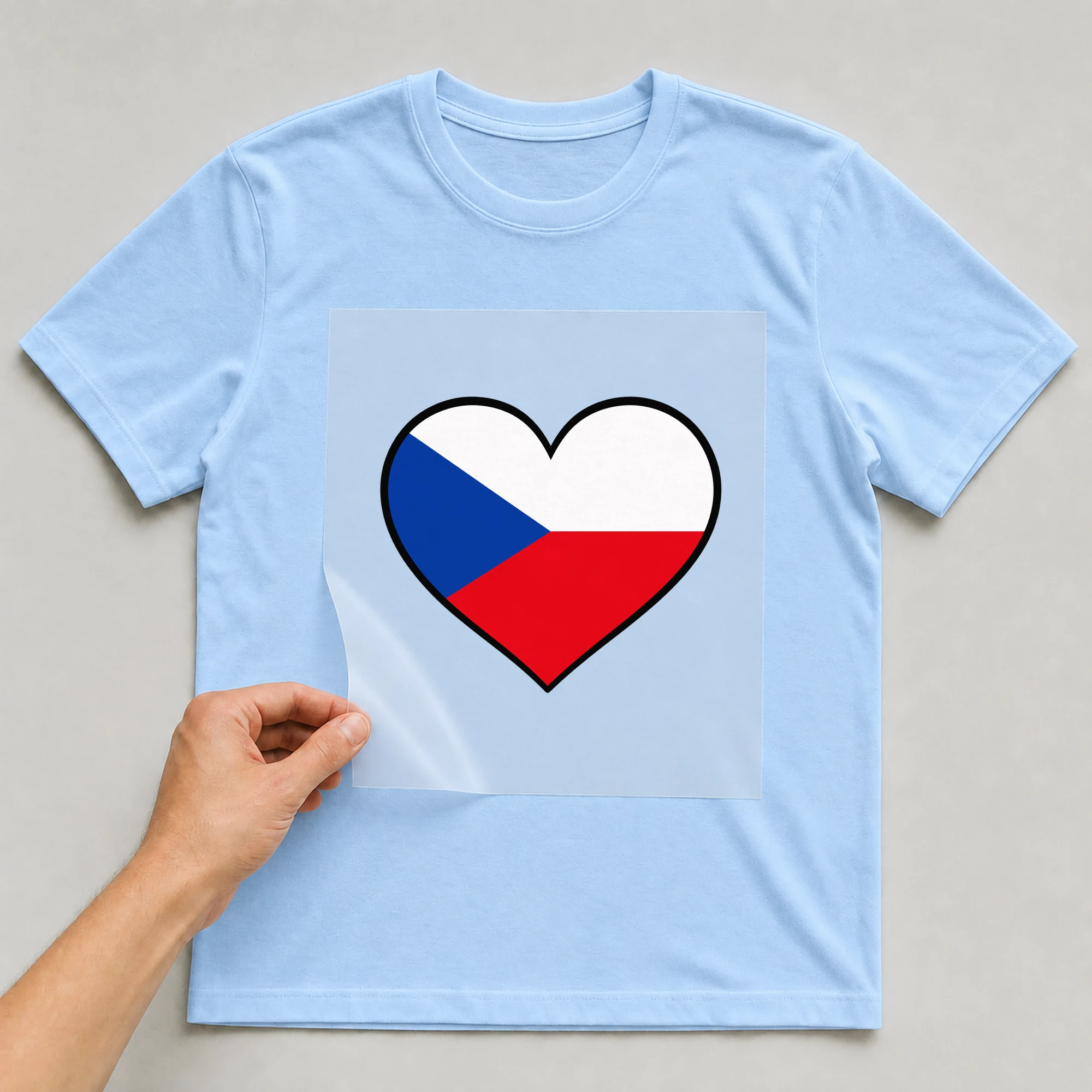 Bügelbild „Herz Flagge Tschechien“ auf babyblauem T-Shirt, Folie wird aufgelegt