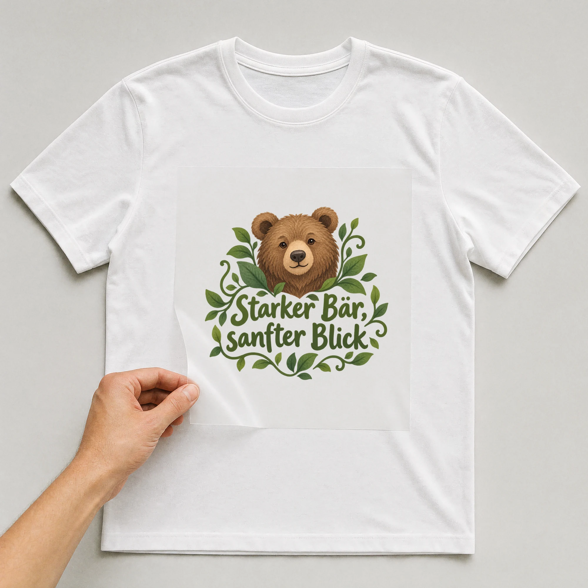 Bügelbild „Starker Bär, sanfter Blick“ auf weißem T-Shirt, Folie wird aufgelegt