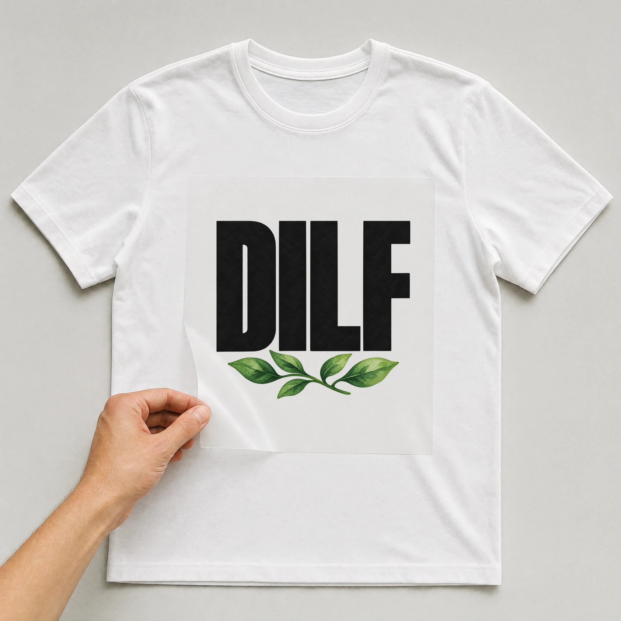 Bügelbild „DILF“ auf weißem T-Shirt, Folie wird aufgelegt