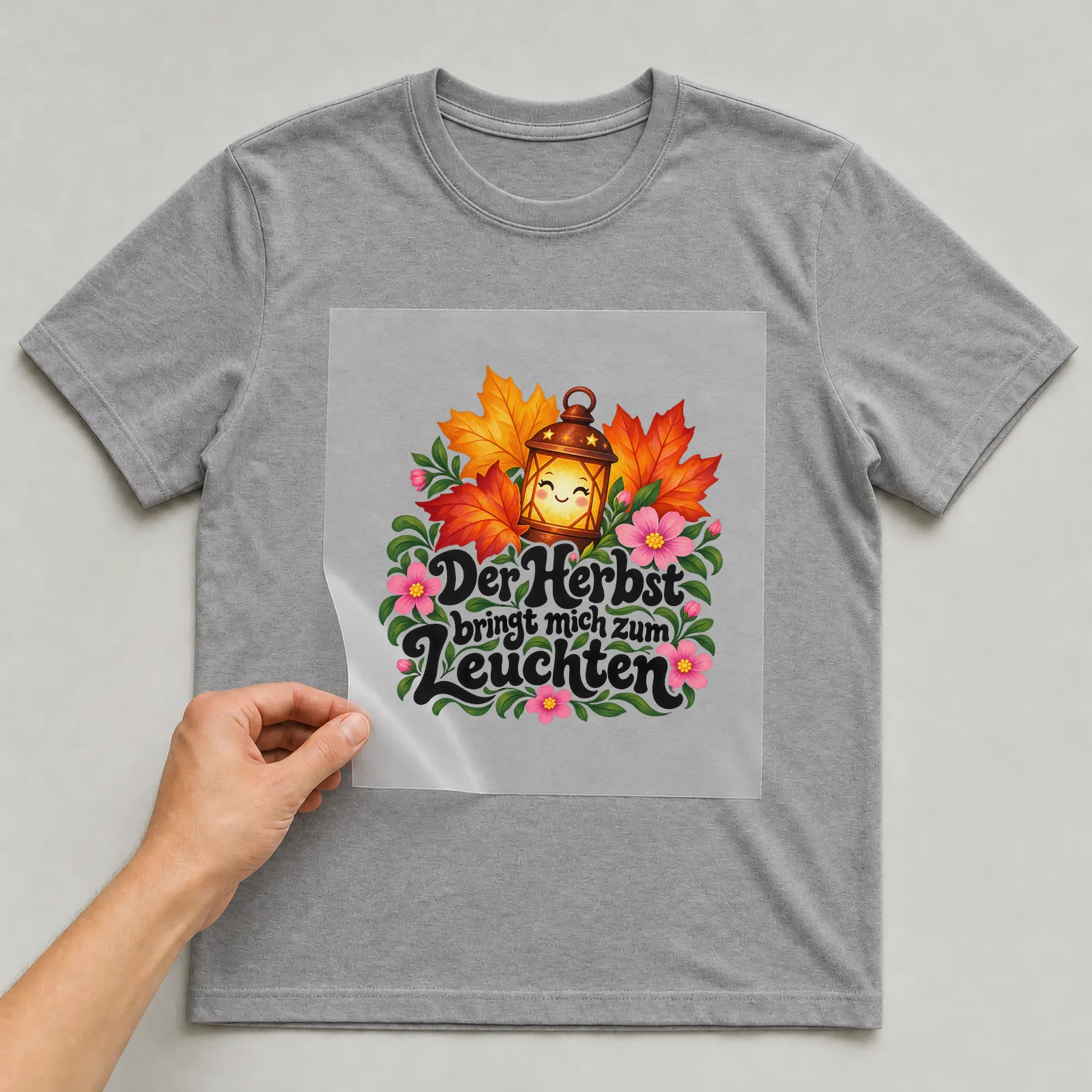Bügelbild „Der Herbst bringt mich zum Leuchten“ auf grauem T-Shirt, Folie wird aufgelegt