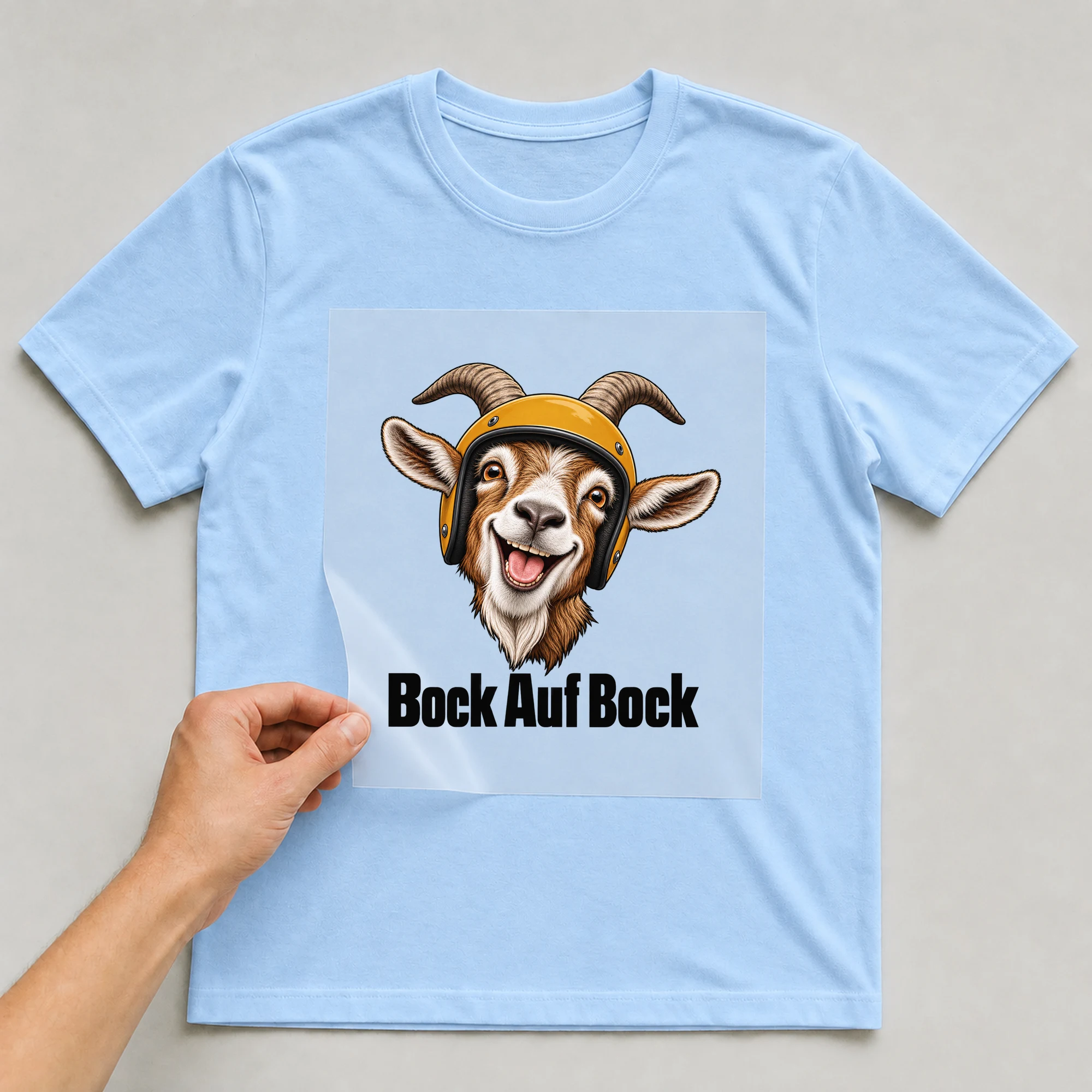 Bügelbild „Bock Auf Bock“ auf babyblauem T-Shirt, Folie wird aufgelegt