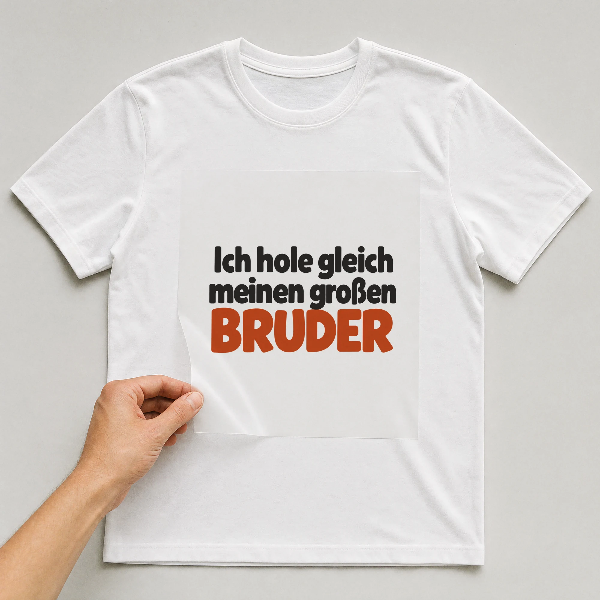 Bügelbild „Ich hole gleich meinen großen BRUDER“ auf weißem T-Shirt, Folie wird aufgelegt