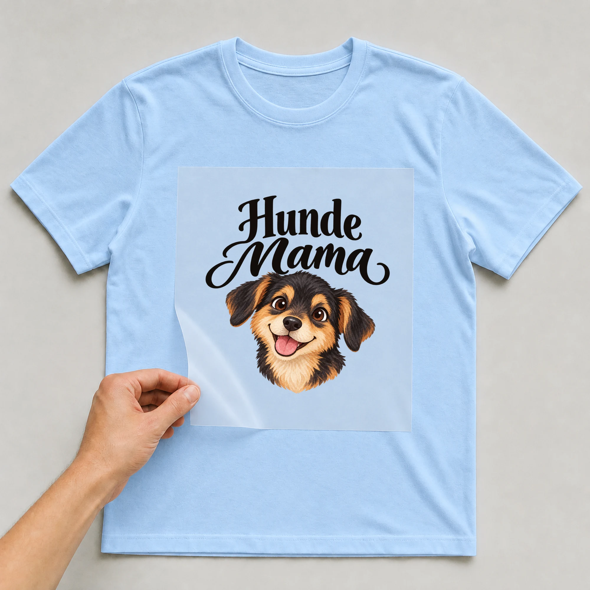 Bügelbild „Hunde Mama“ auf babyblauem T-Shirt, Folie wird aufgelegt