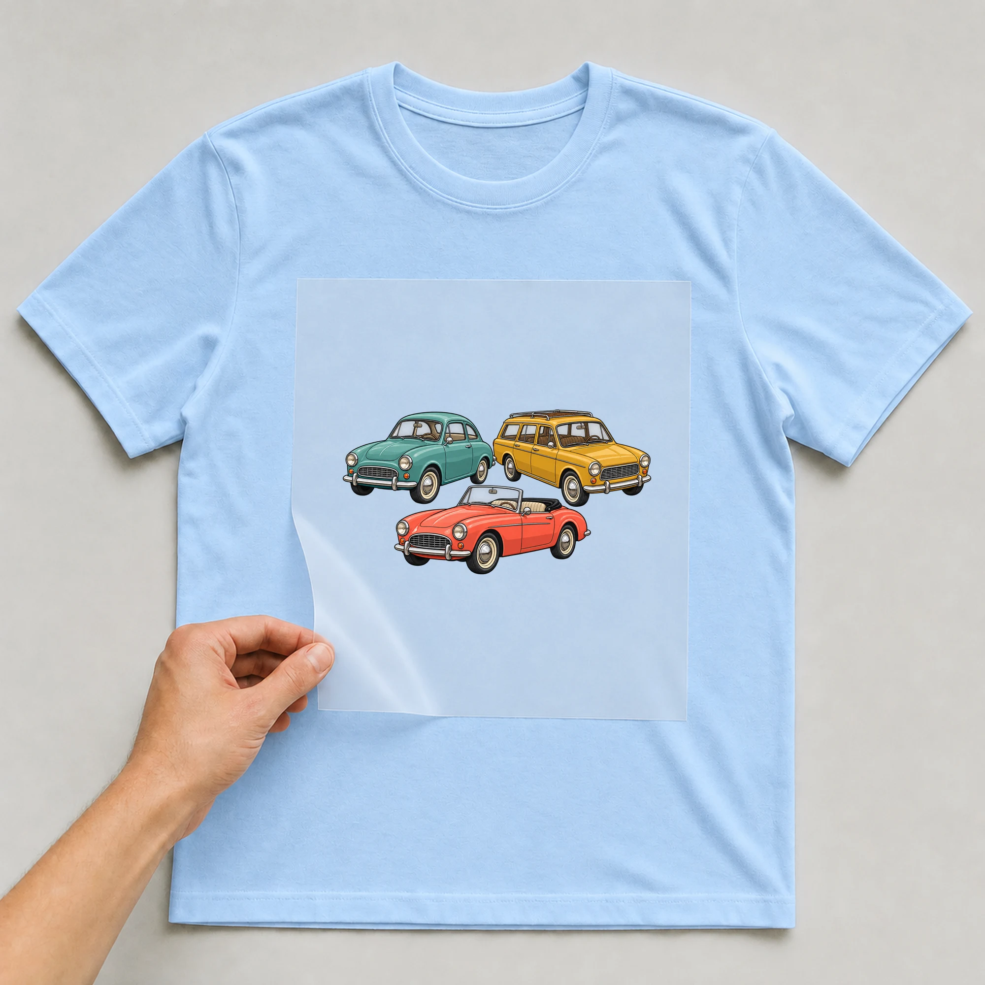 Bügelbild „Retro Cars Collection“ auf babyblauem T-Shirt, Folie wird aufgelegt