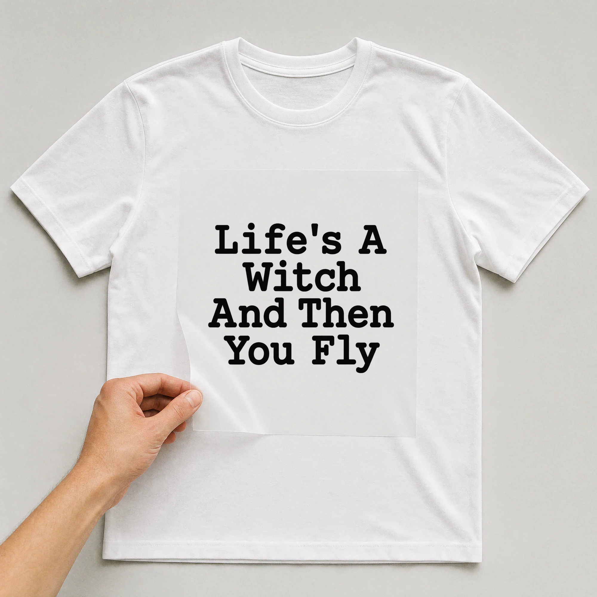 Bügelbild „Life's A Witch And Then You Fly“ auf weißem T-Shirt, Folie wird aufgelegt