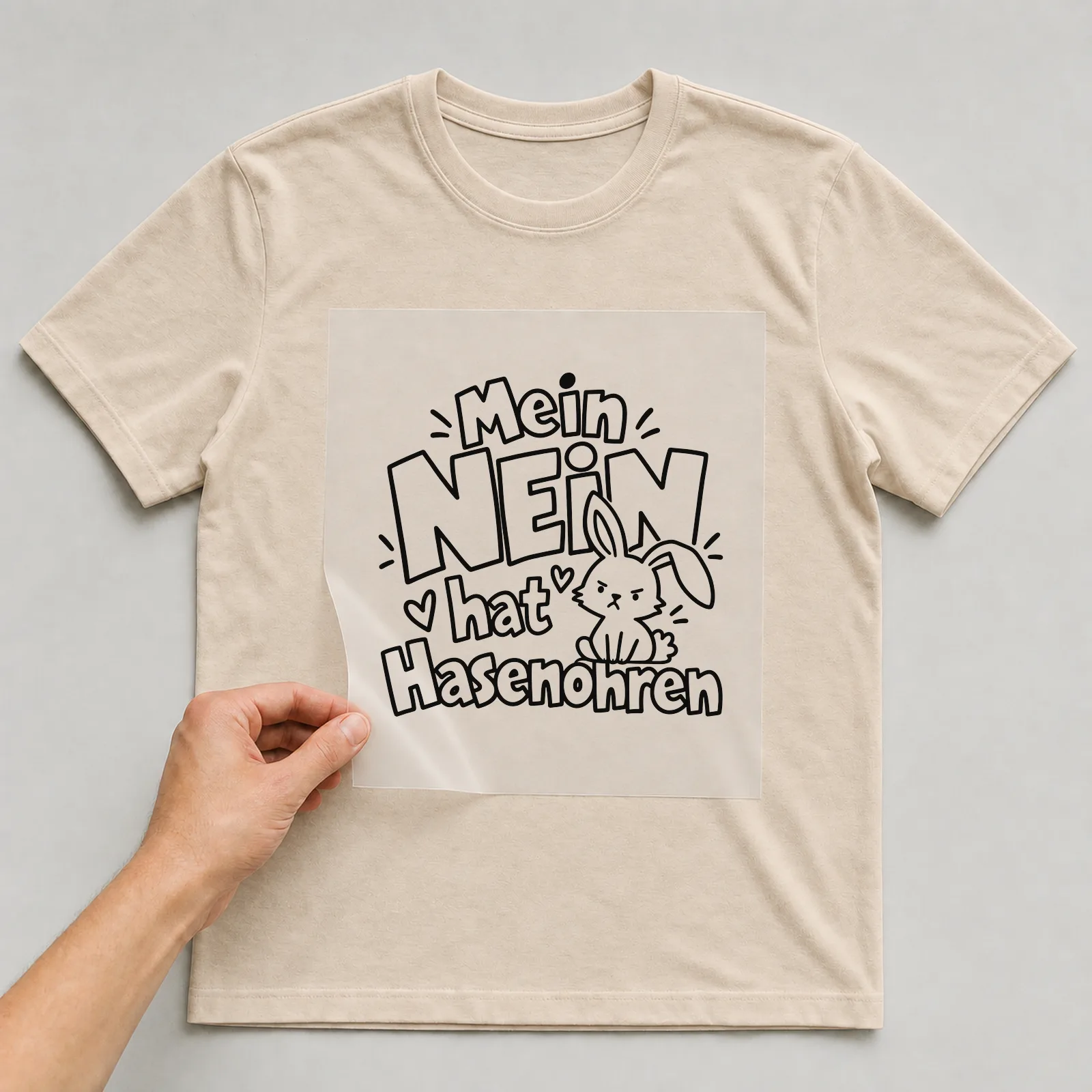 Bügelbild „Mein Nein hat Hasenohren“ auf beigem T-Shirt, Folie wird aufgelegt