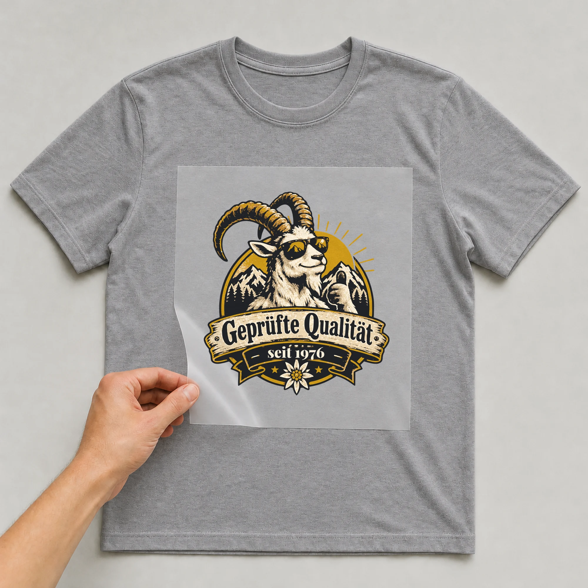 Bügelbild Geprüfte Qualität mit Jahr auf grauem T-Shirt, Folie wird aufgelegt