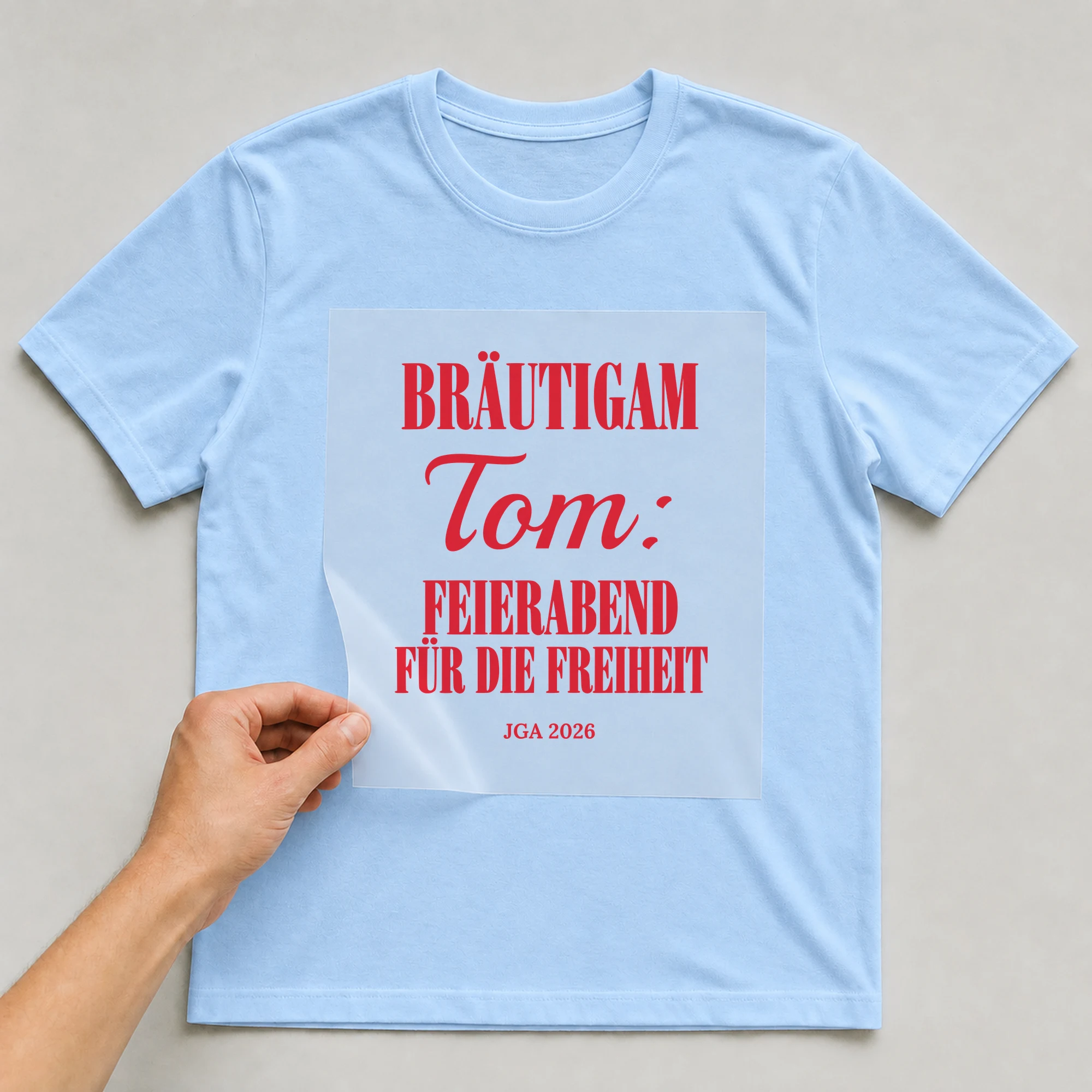 Bügelbild Bräutigam: Feierabend für die Freiheit mit Name auf hellblauem T-Shirt, Folie wird aufgelegt