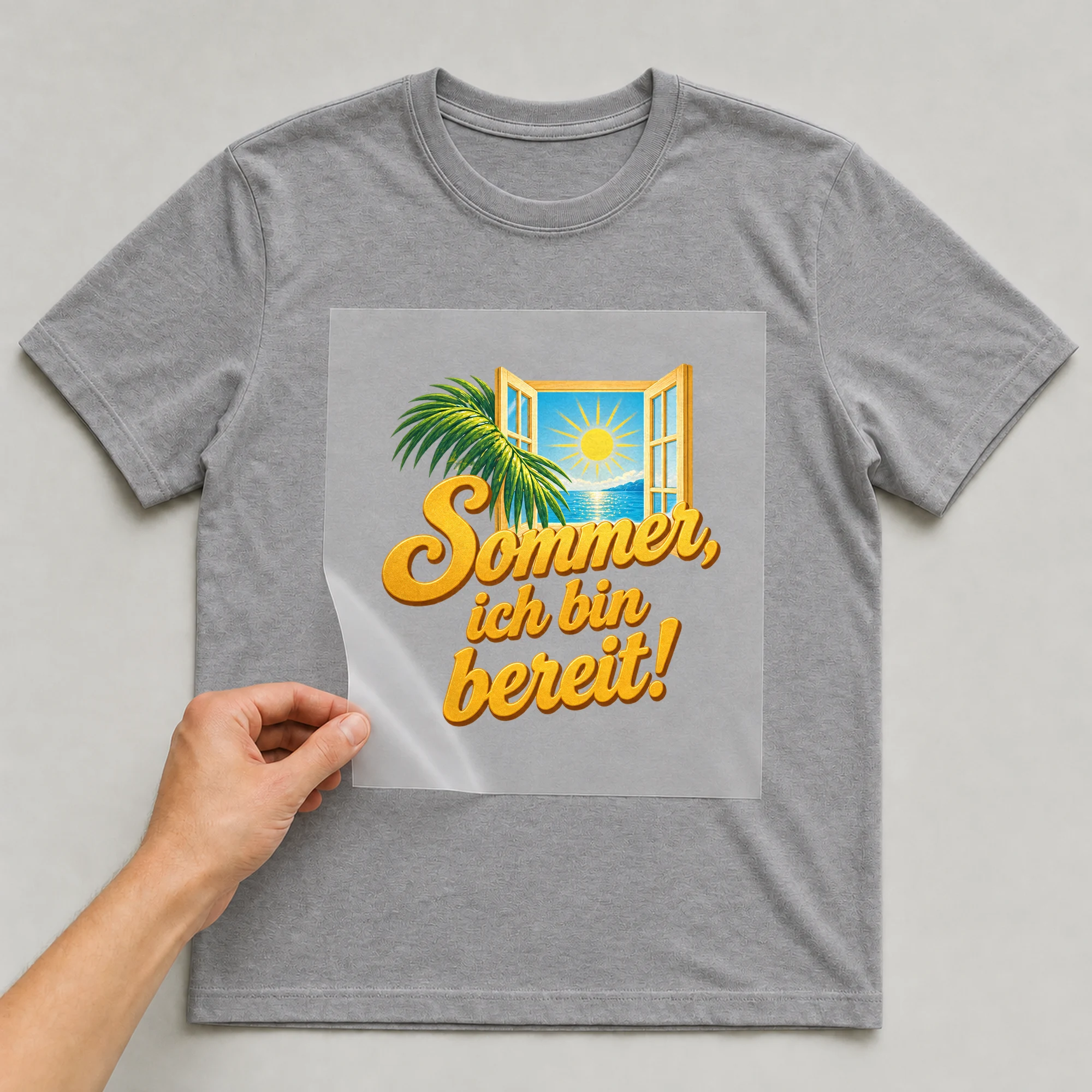 Bügelbild „Sommer steht mir offen“ auf grauem T-Shirt, Folie wird aufgelegt