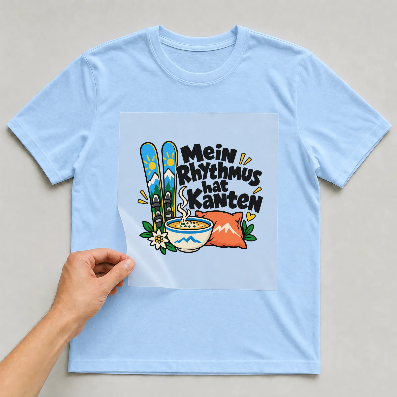 Bügelbild „Mein Rhythmus hat Kanten“ auf hellblauem T-Shirt, Folie wird aufgelegt