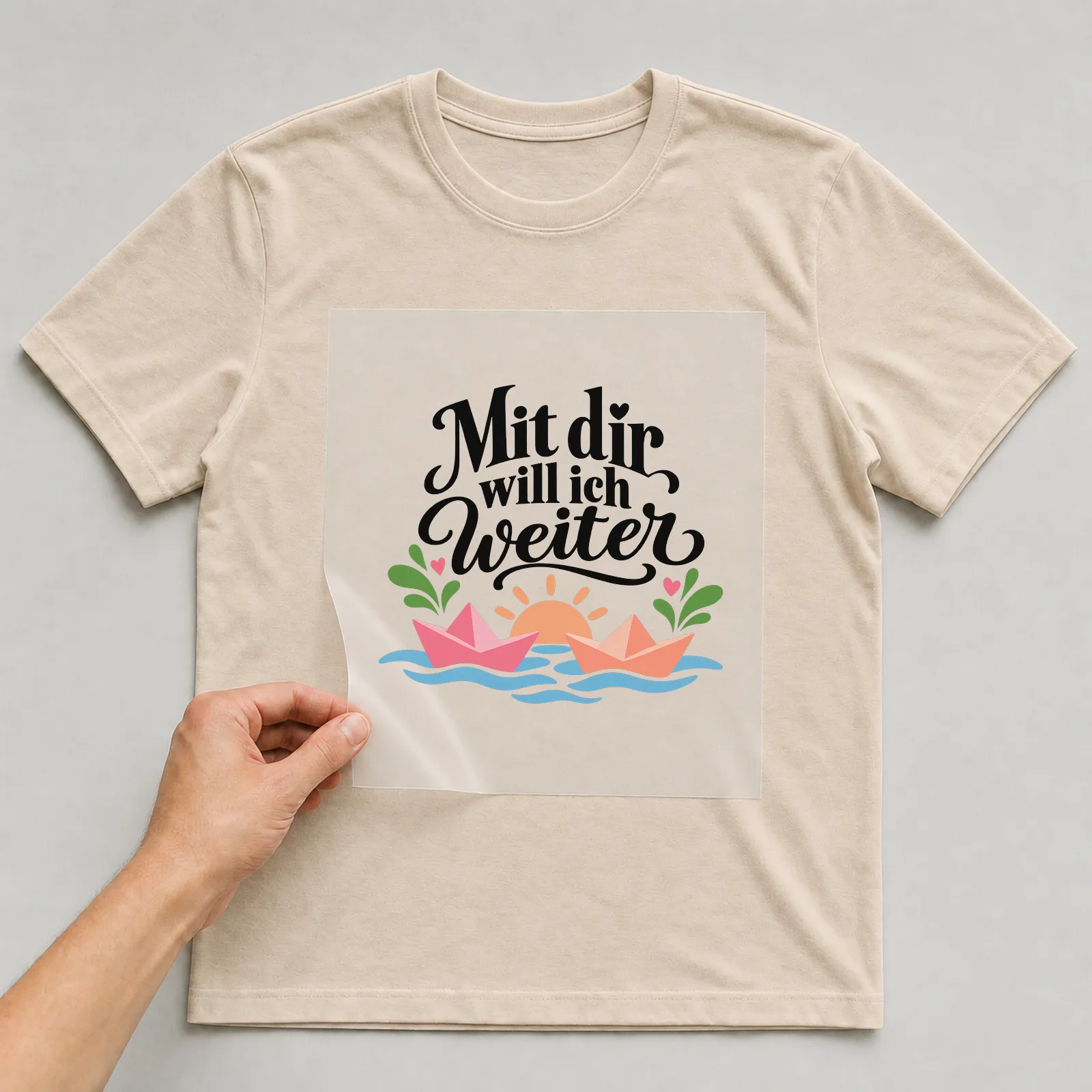 Bügelbild „Mit dir will ich weiter“ auf beigem T-Shirt, Folie wird aufgelegt